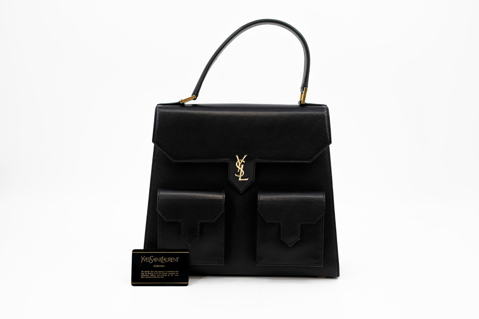 A vintage Yves Saint Laurent handbag in black leather: A vintage Yves Saint Laurent handbag in black leather with gold-toned hardware. Comes with its dustbag and certificate. Condition: this bag is in vintage but well-maintained condition, the leather pre