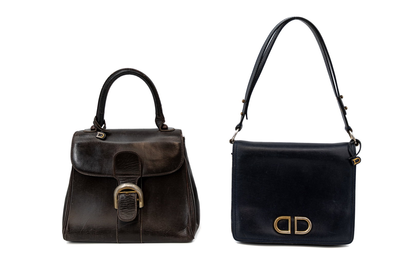 A composed lot of two vintage Delvaux handbags in leather: A composed lot of two vintage Delvaux handbags in leather, one Delvaux Brillant in dark brown leather and one Delvaux Camargue in navy blue leather. One comes with a vanity mirror and both come with t