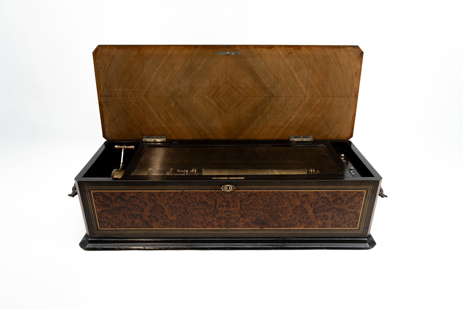 An imposing and large antique cylindrical music box: An imposing and large antique cylindrical music box with inlay marquetry walnut veneer and mother of pearl, mounted brass handles. In playing condition, but has been out of maintenance for a long time