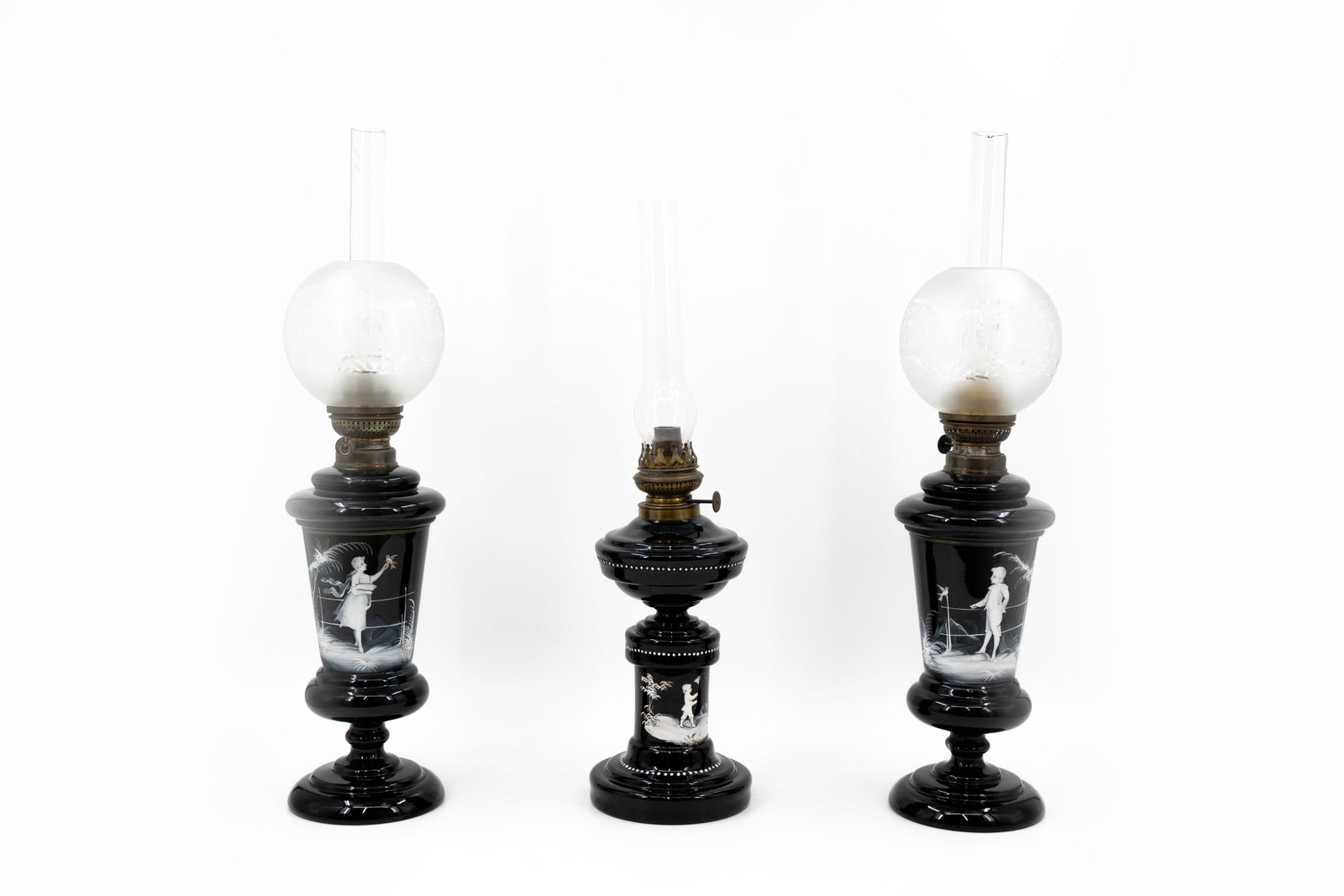 A matching lot of three antique opaline glass figural decorated oil lamps: A matching lot of three antique opaline glass figural decorated oil lamps. Circa 1900-1920s. H: 58 - 64,5 cm