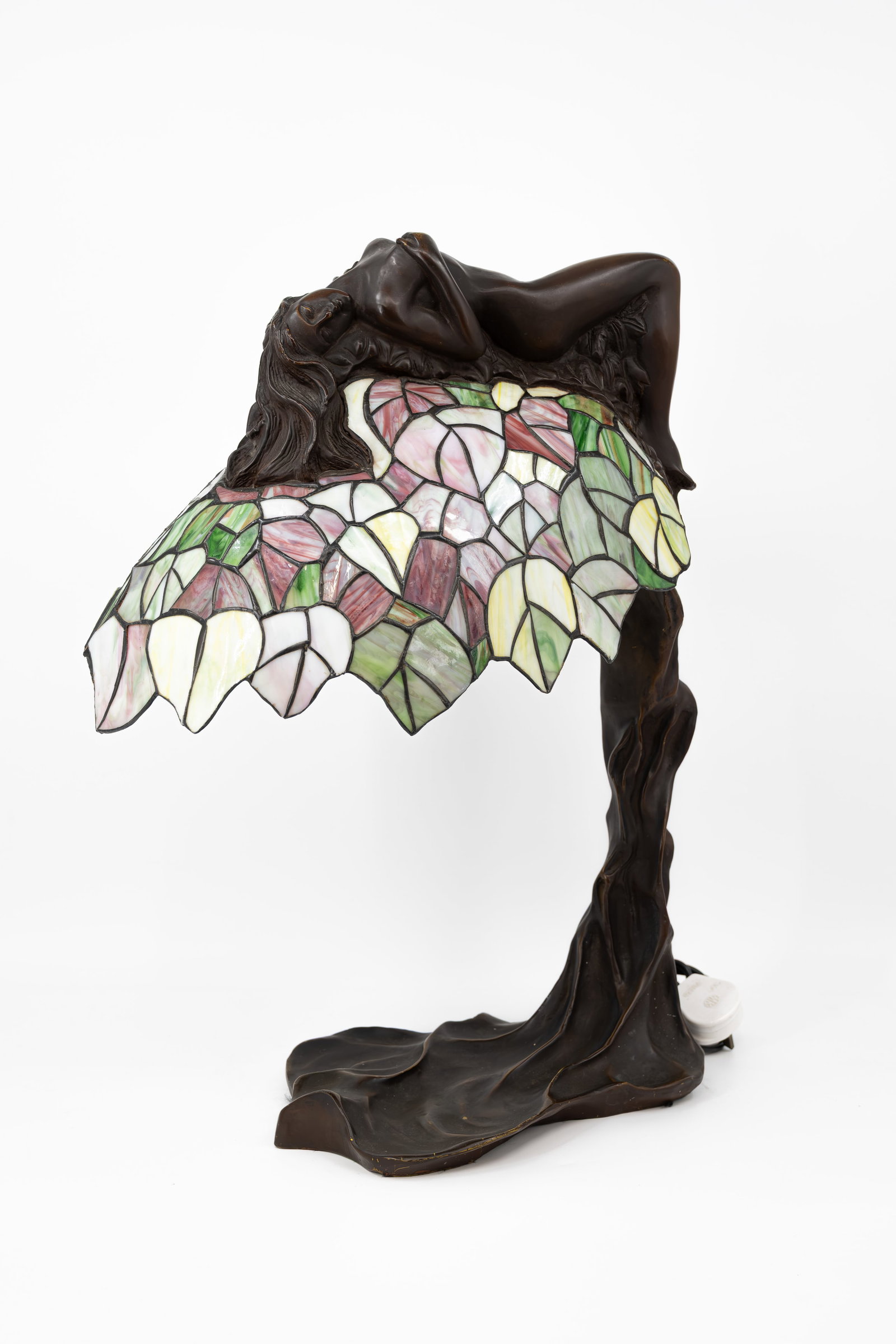 A 20th century Tiffany style glass mounted and figural patinated bronze table lamp: A 20th century Tiffany style glass mounted and figural patinated bronze table lamp with a figure of a nude lady. Circa 1970s. H: 59 cm