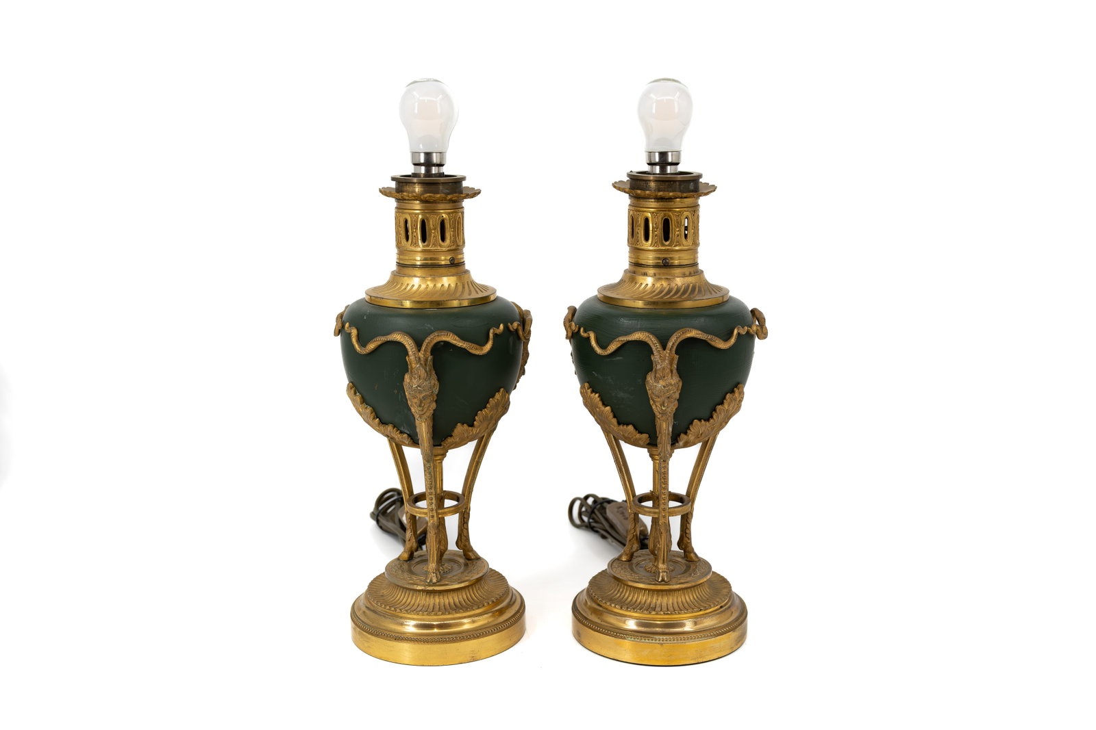 A pair of French gilt bronze and patinated brass table lamps with Bacchus shaped heads: A pair of French gilt bronze and patinated brass table lamps with Bacchus shaped heads and tripod decoration. 20th century. H: 35,5 cm