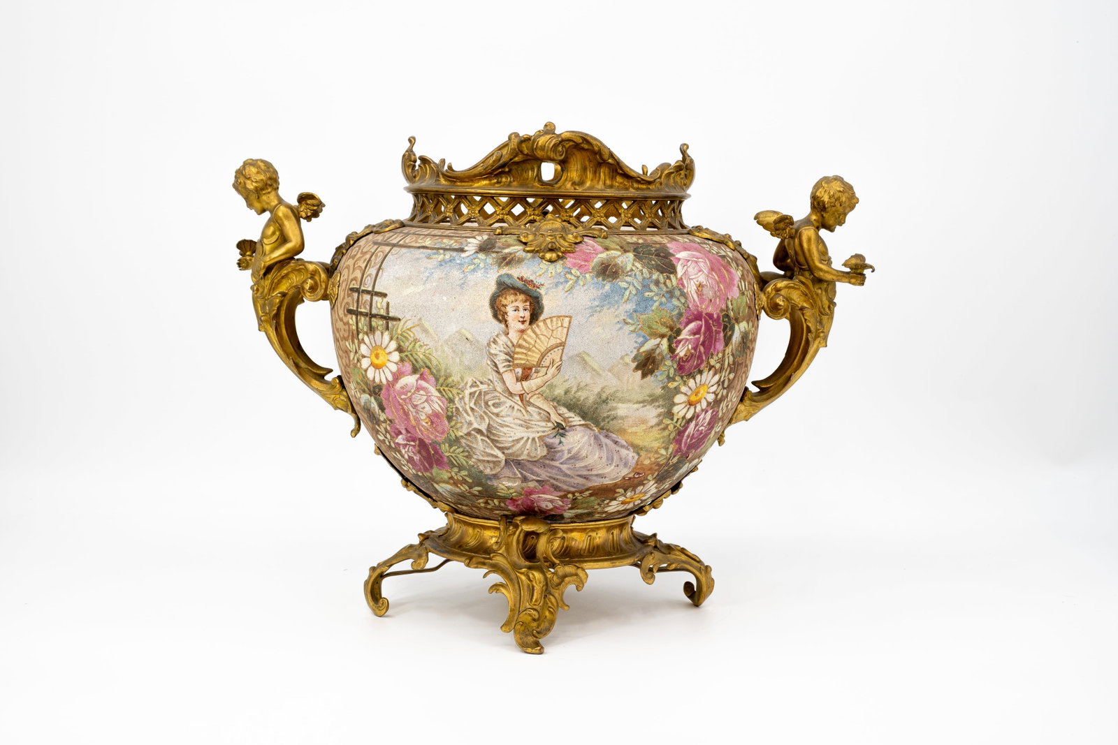 An antique French gilt bronze mounted ceramic decorated centerpiece cache pot: An antique French gilt bronze mounted ceramic decorated centerpiece cache pot. Unmarked, circa 1900-1920s. H: 34 - W: 46 cm