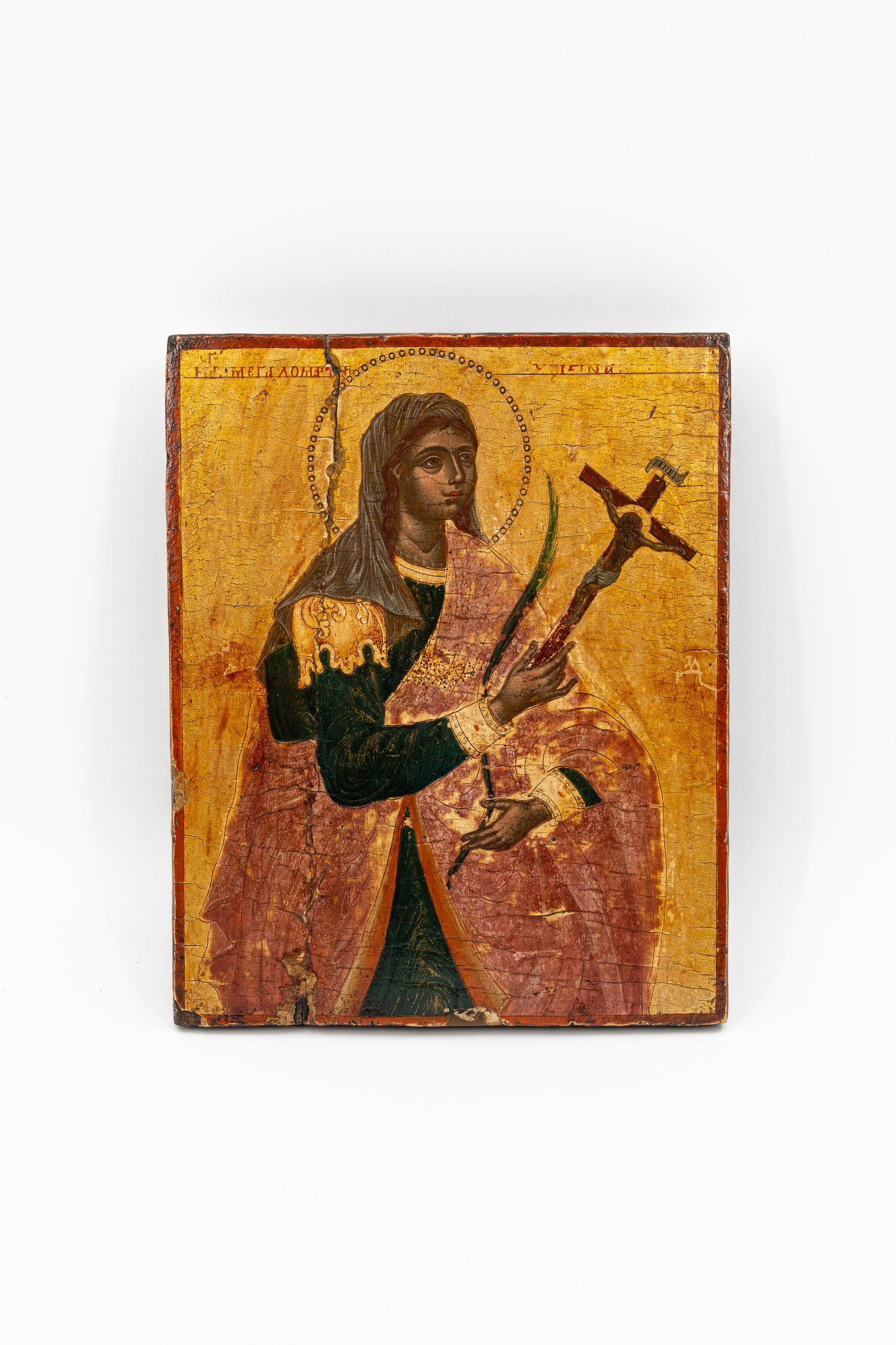 An Orthodox tempera on panel icon depicting a female martyr holding a crucifix: An Orthodox tempera on panel icon depicting a female martyr holding a crucifix, with gilt background. Russia, 19th/20th century. H: 26 - W: 21 cm