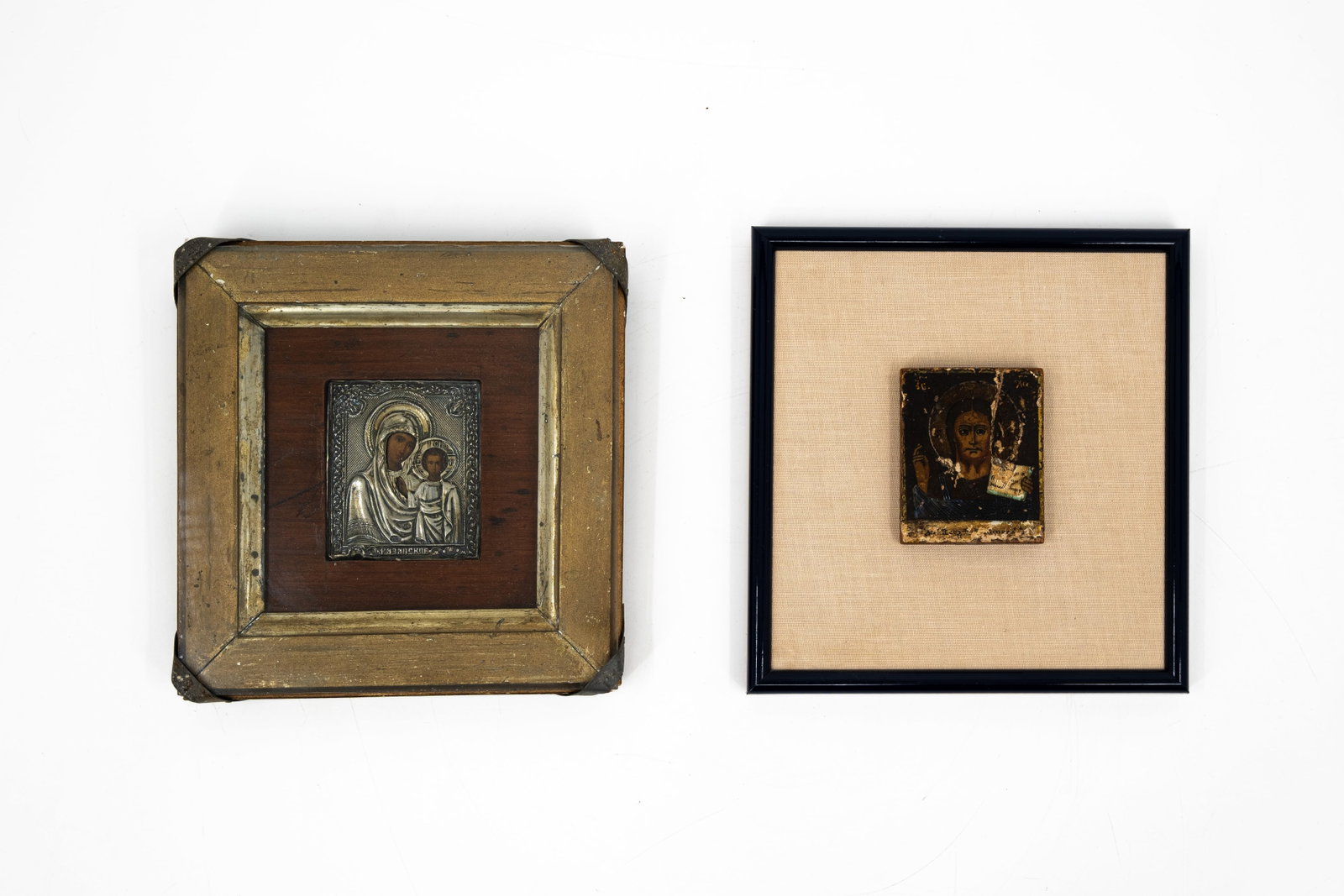 A composed lot of two small antique Russian icons, tempera on wood, variously decorated: A composed lot of two small antique Russian icons, tempera on wood, variously decorated. One with a silver oklad, on a wood and textile frame and one is glass protected. Hallmarks and 19th century. H: