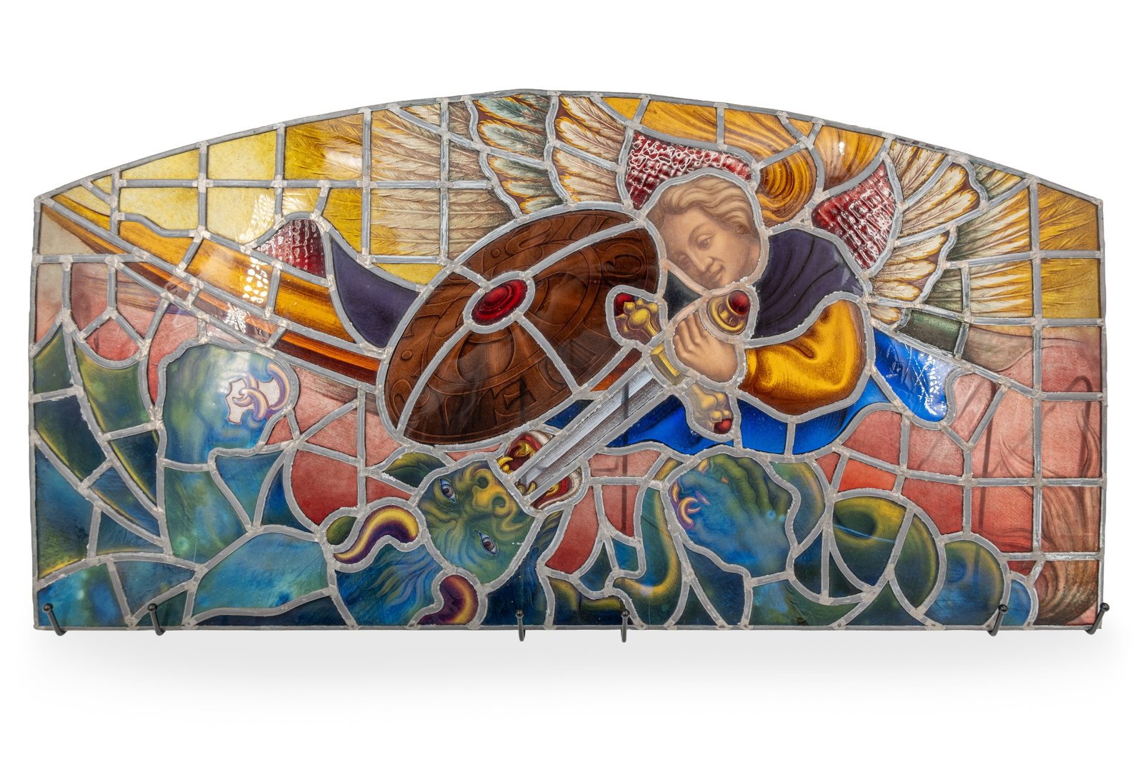 A large antique finely decorated stained-glass panel depicting a religious scene: A large antique finely decorated stained-glass panel depicting a religious scene with Saint Michael fighting a dragon. First half 20th century. H: 43,5 - W: 86 cm