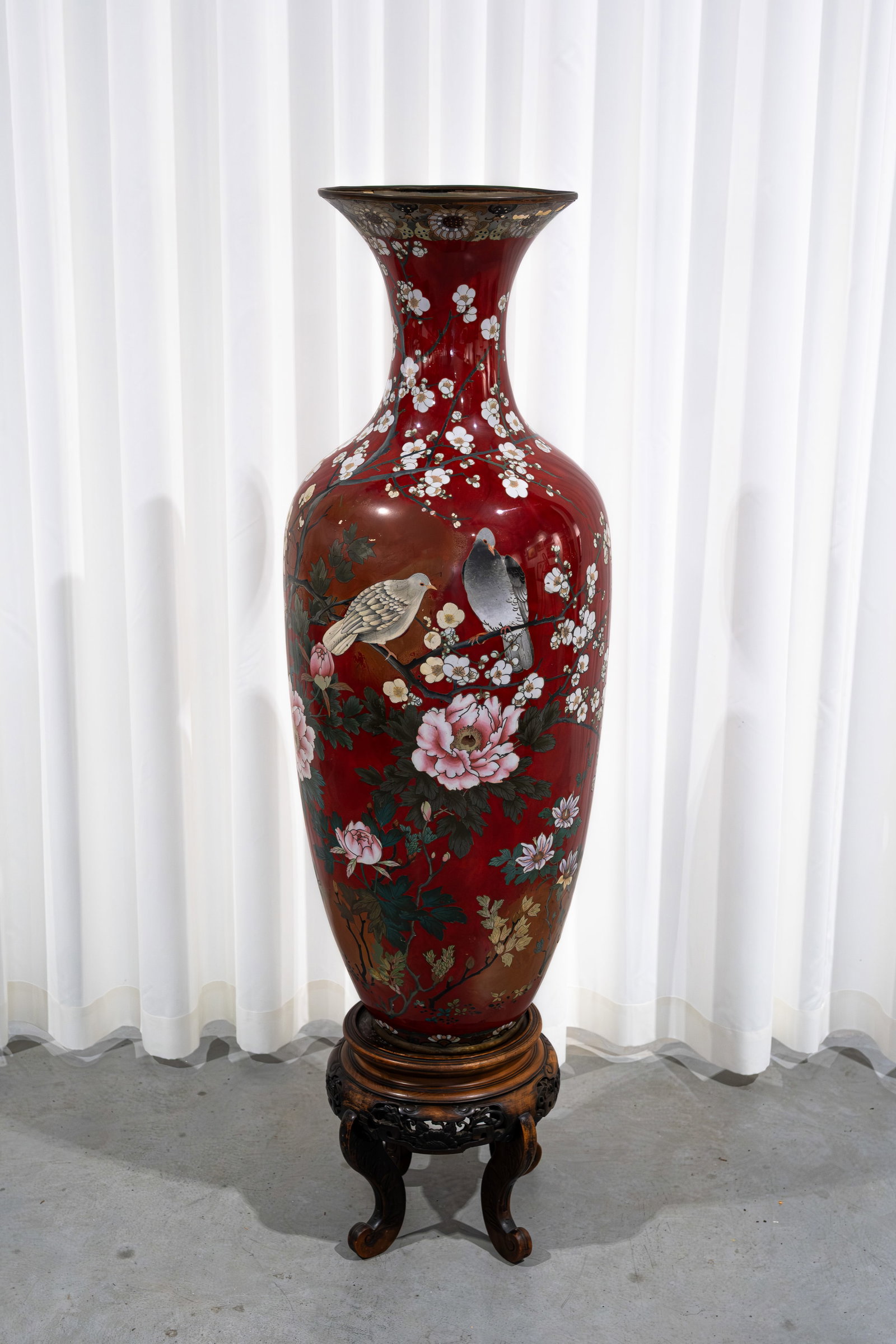 An imposing and large Japanese richly decorated cloisonne vase: An imposing and large Japanese cloisonne vase richly decorated with birds and branches, footed on a wooden base. Circa 1900-1920s. Shows some damages and restorations. Report available on request. H: 