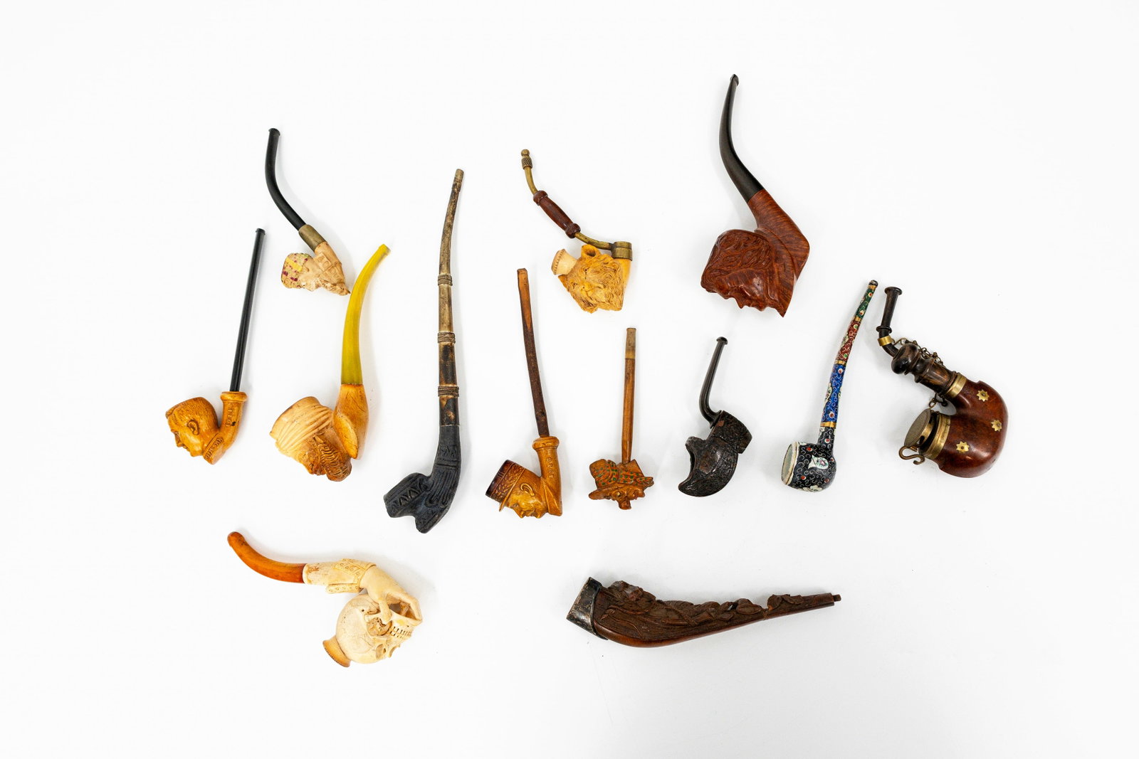 A composed collection of 13 variously shaped antique pipes: A composed collection of 13 variously shaped antique pipes with figures in pipe clay, carved wood and enamel. 19th/20th century. L: 10,5 - 25,5 cm