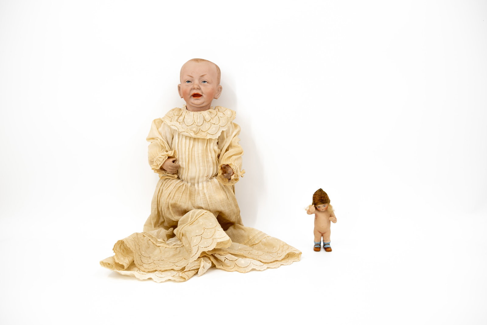 An antique A Kammer & Reinhardt 100 old doll with bisquit head, together with a miniature old doll: An antique A Kammer & Reinhardt 100 old doll with bisquit head, together with a miniature old doll. Both made in Germany, circa 1900-1920s. H: 12 - 35 cm
