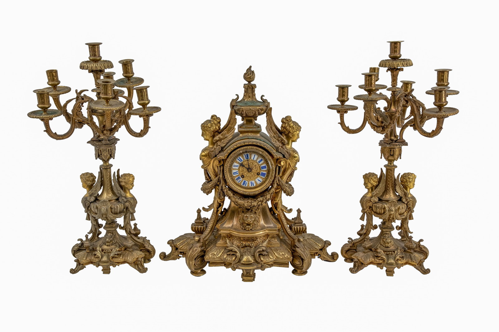 A large antique French Louis X- style gilt bronze mantle clock set marked by G.Phillipe à Paris: A large and antique French Louis XV style gilt bronze mantle clock with matching candelabras marked by G.Phillipe for Palais Royal a Paris, finely decorated with a winged lady, putti and a lion head. 