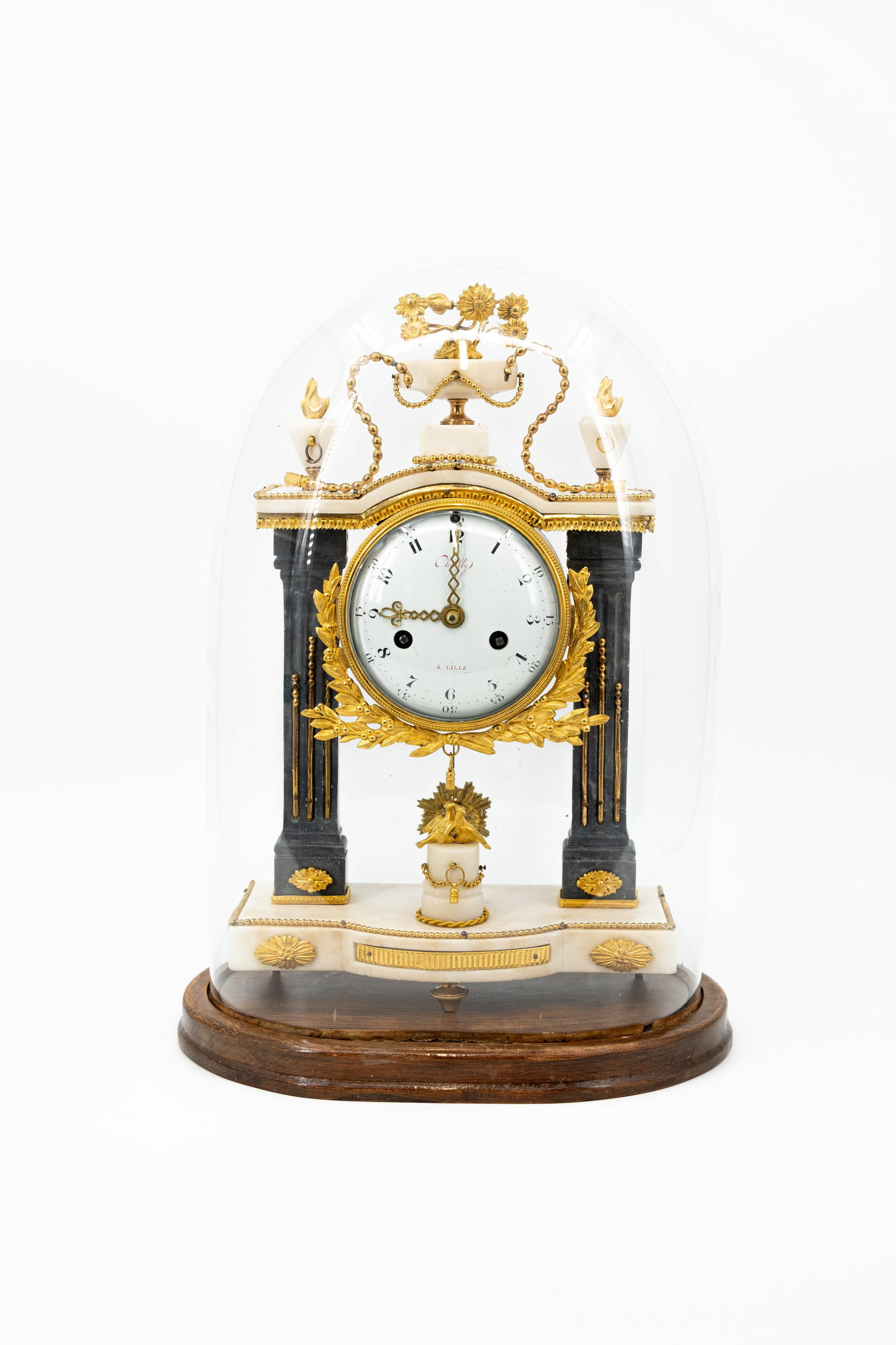 A French Louis XVI style marble and gilt bronze portico clock protected under a glass dome: A French Louis XVI style marble and gilt bronze portico clock protected under a glass dome. Dial signed by Chailly a Lille. 19th century. H: 40 - W: 25 cm