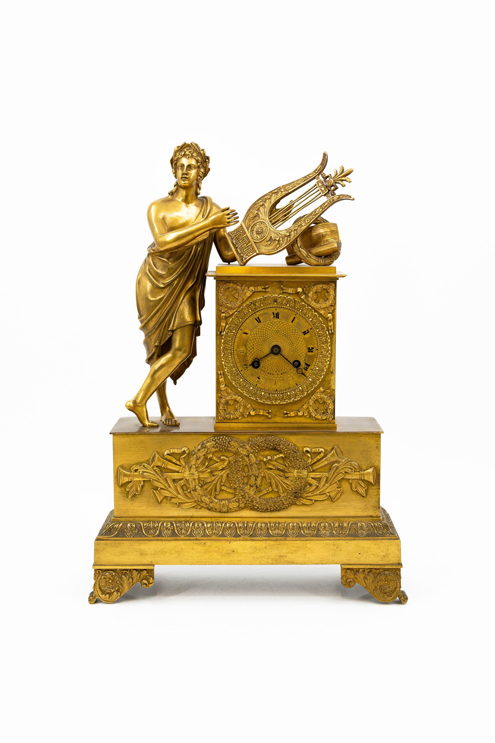 A French Empire gilt bronze figural mantel clock decorated with Apollo: A French Empire gilt bronze figural mantel clock decorated with Apollo as lyre player. 19th century. H: 41,5 - W: 29,5 cm