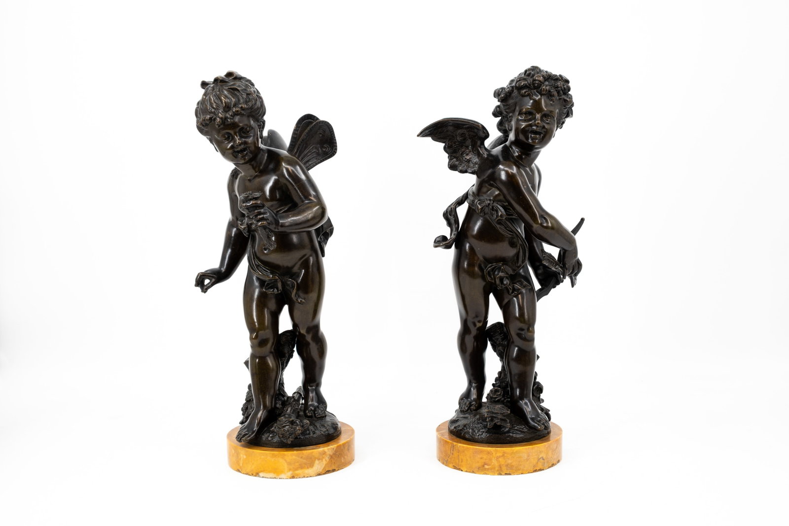 A matching pair of antique patinated bronze sculptures of putti: A matching pair of antique patinated bronze sculptures of putti. Footed on ochre yellow marble bases. Unsigned, late 19th century. H: 41 cm, without base