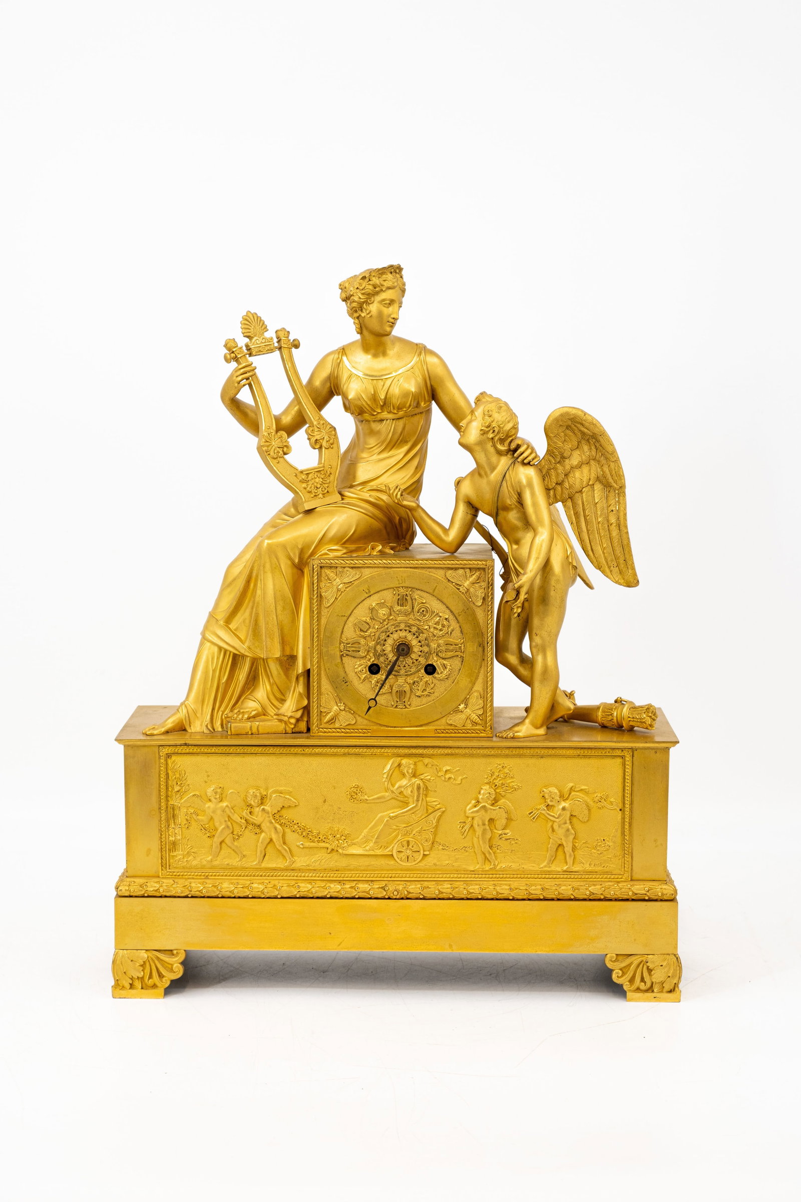 An antique gilt bronze French Empire figural mantel clock representing Venus and Cupid: An antique gilt bronze French Empire figural mantel clock representing Venus and Cupid. Decorated with an allegorical scene of winged putti and chariot. 19th century. H: 49 - W: 38,5 cm