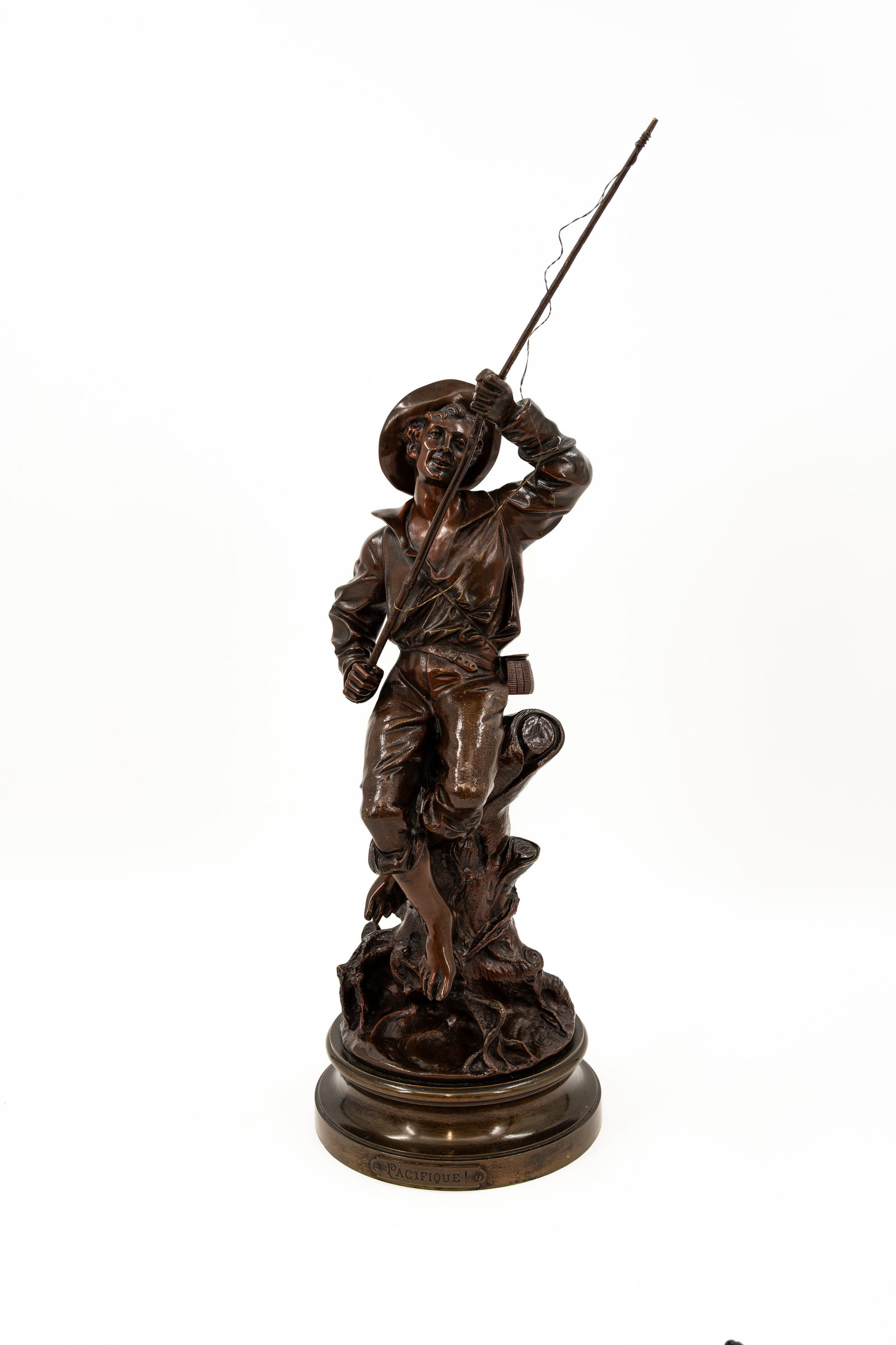 An antique French patinated bronze sculpture of a fisher: An antique French patinated bronze sculpture of a fisher titled "Pacifique!". Illegibly signed. Late 19th century. H: 58 cm