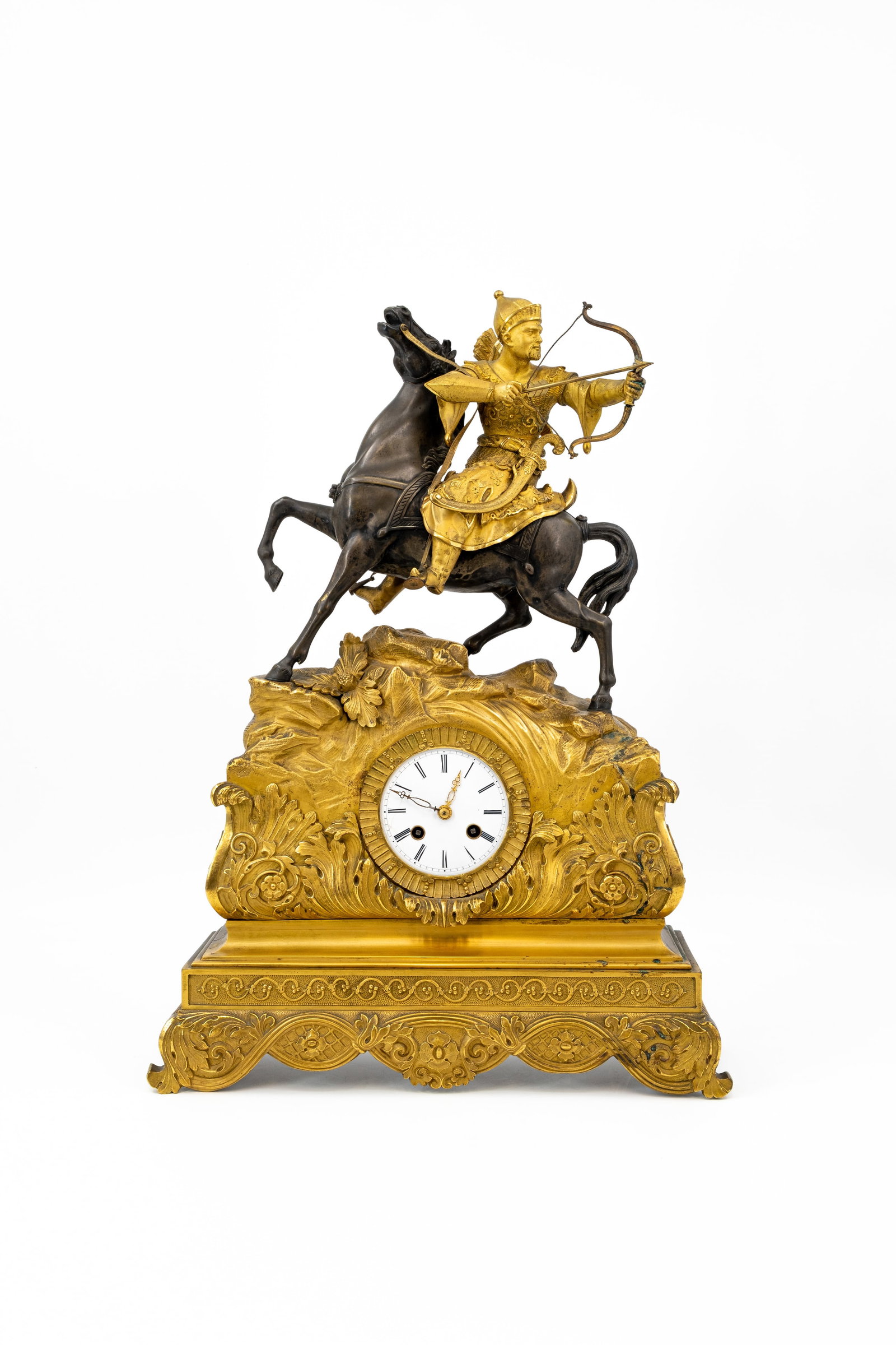 An antique French gilt and patinated bronze figural mantel clock with an Asian hunter: An antique French gilt and patinated bronze figural mantel clock with an asian hunter on horseback. 19th century. H: 54 - W: 39 cm