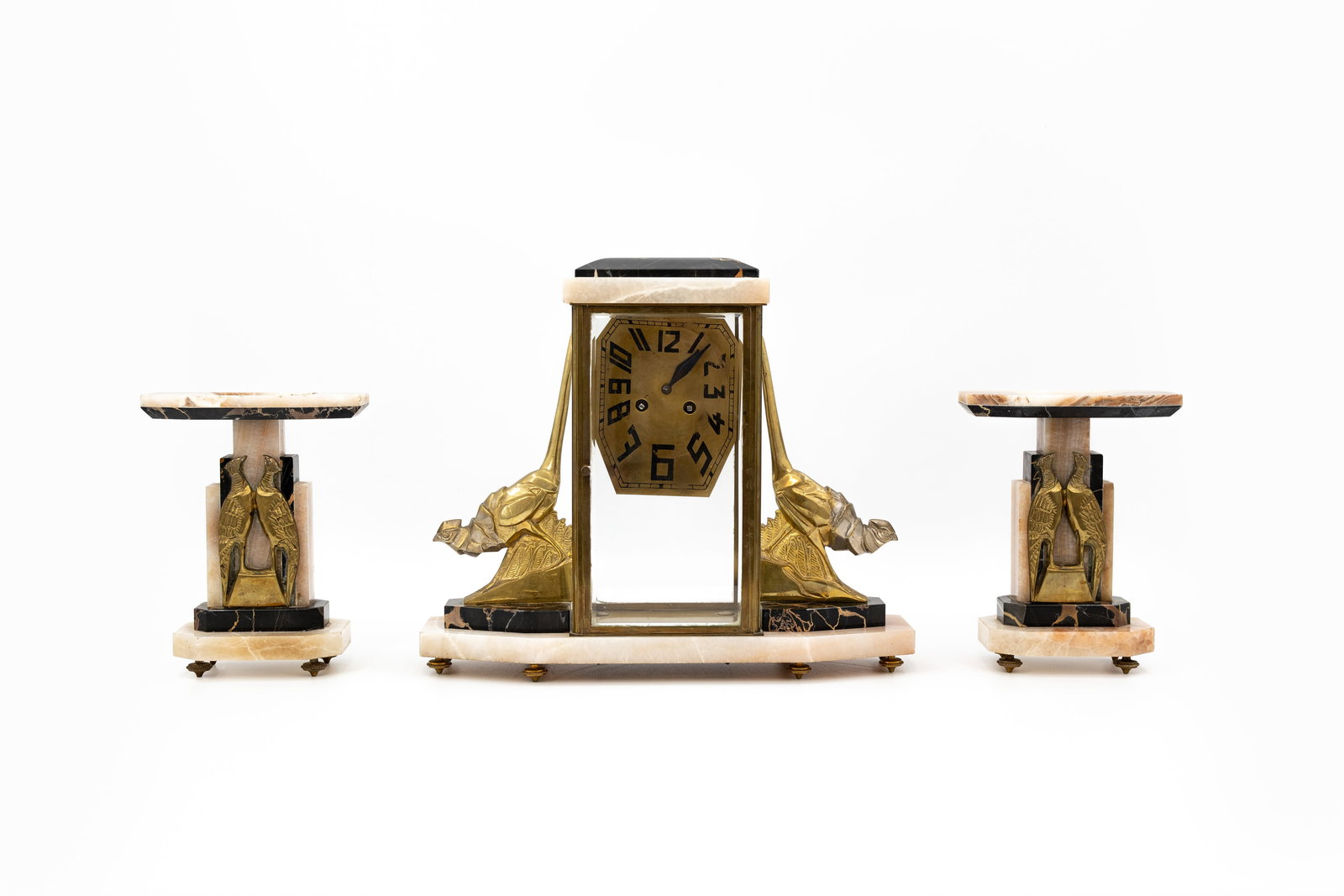 An art deco mantel clock set decorated with stylized pheasants on a bi-color marble base: An art deco mantel clock set decorated with stylized pheasants on a bi-color marble base. Circa 1900-1920s. Including pendulum and key. H: 33 - W: 39 cm, clock