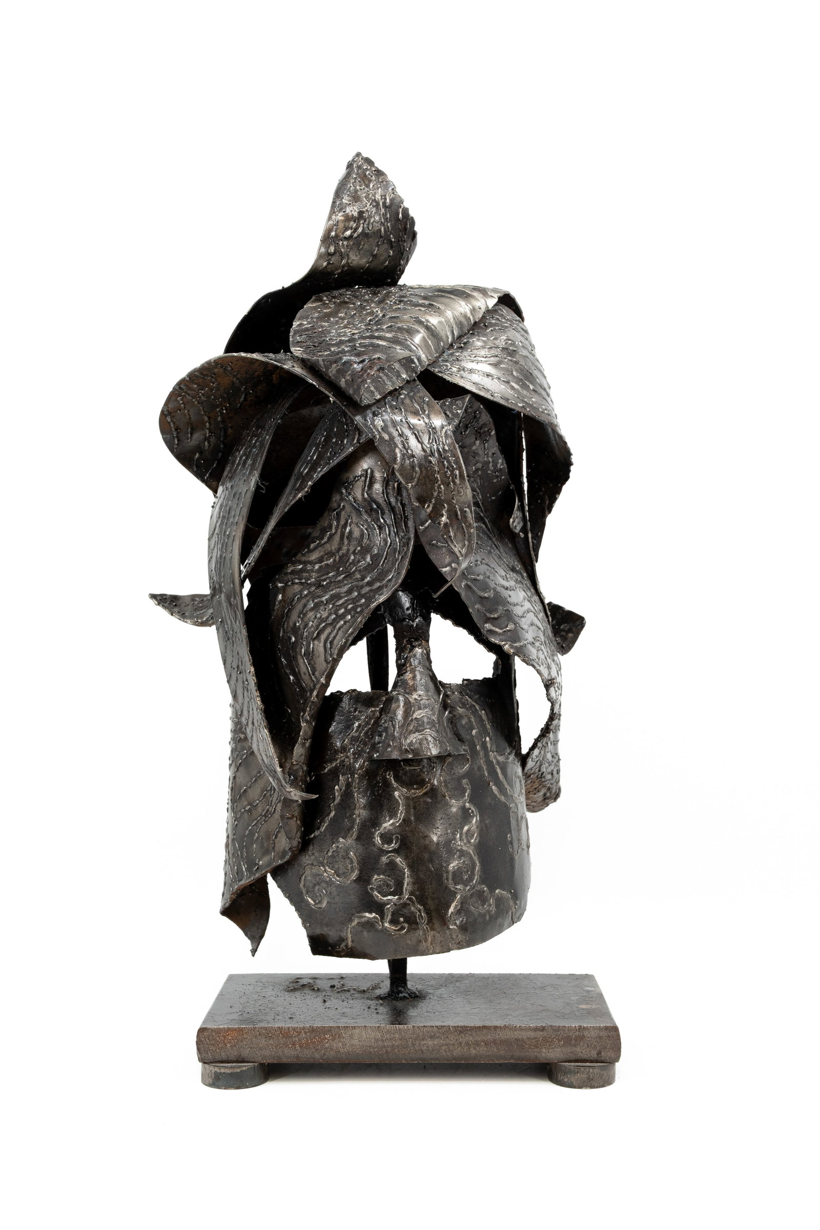 A 20th century modernistic reliëf patinated steel art sculpture: A 20th century modernistic reliëf patinated steel art sculpture of a mask, mounted on a cast iron base. Monogram marked: M.V. - circa 1970s. H: 65 cm