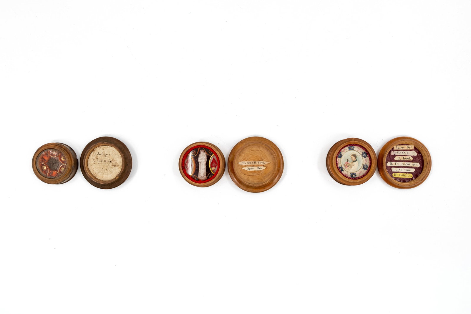 A lot of three sealed thecas containing relics, one of which is from the True Cross: A composed lot of three sealed thecas containing relics. Consisting of: a relic of the True Cross, an Agnus Dei wax medallion associated with the Holy Blood, and a multitheca containing an Agnus Dei w