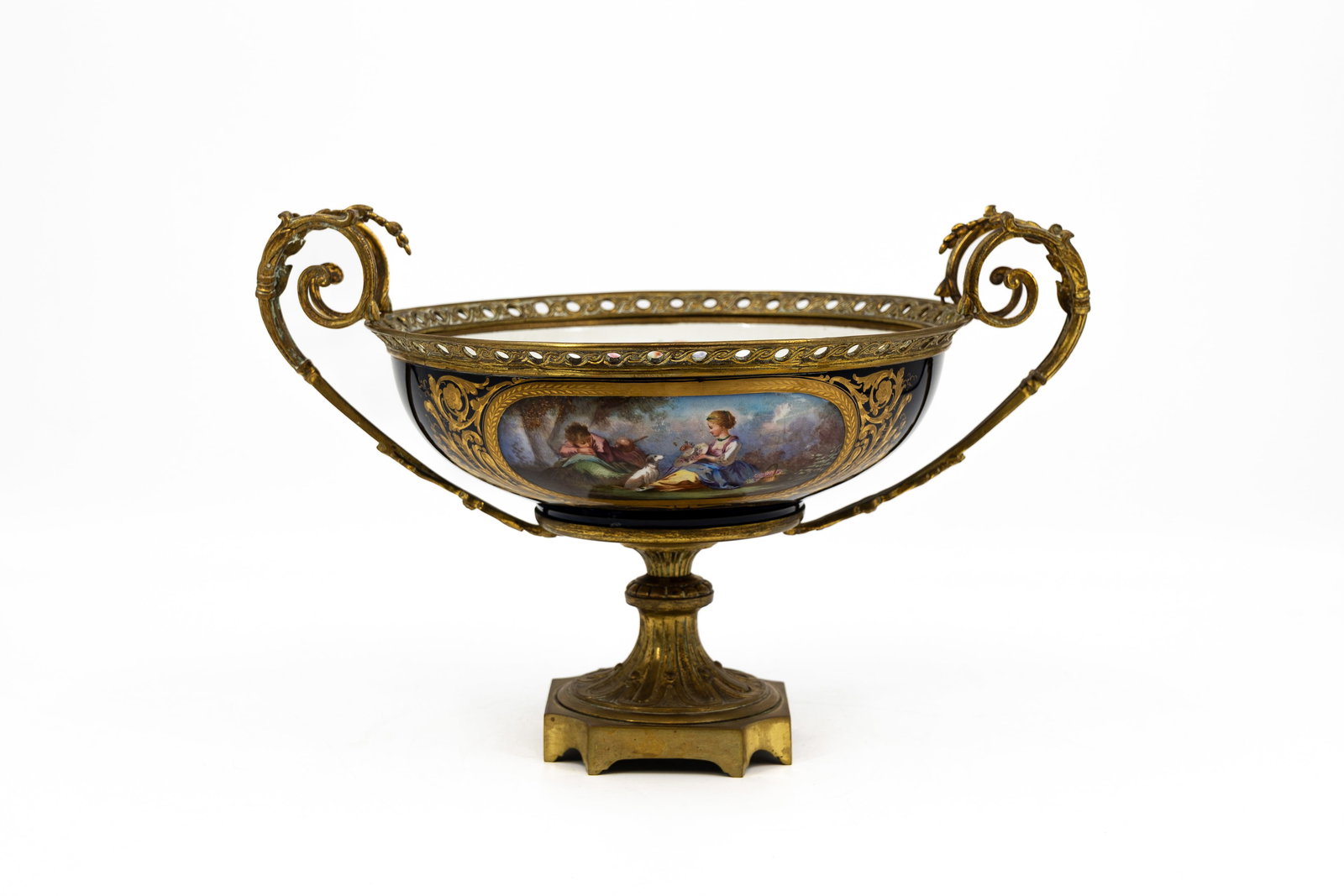 An antique French Sevres style cobalt blue and decorated porcelain centerpiece with bronze mounting: An antique French Sevres style cobalt blue and decorated porcelain centerpiece with bronze mounting, with a hand painted flora and romance scene on both the back and the front . Late 19th century. H: 