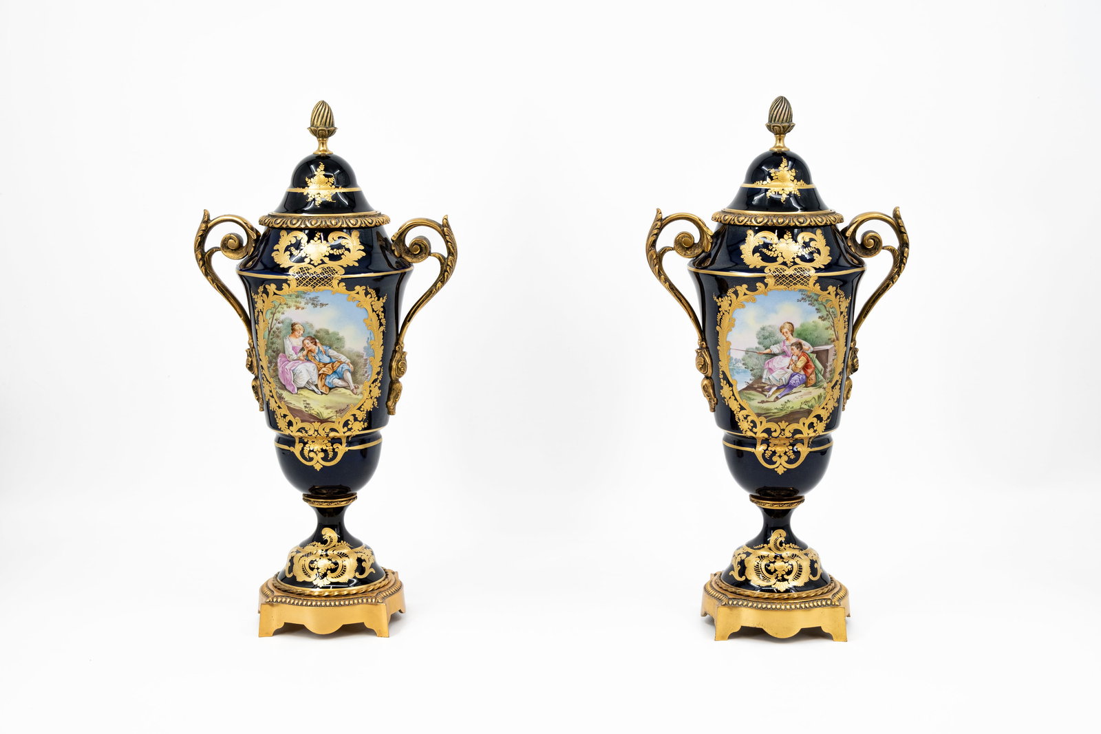 A pair of French Sevres style gilt on cobalt and finely decorated porcelain vases: A pair of French Sevres style gilt on cobalt and finely, with romance scenes, decorated porcelain vases with brass mountings. Signed by J. Missant. 20th century. H: 42,5 cm
