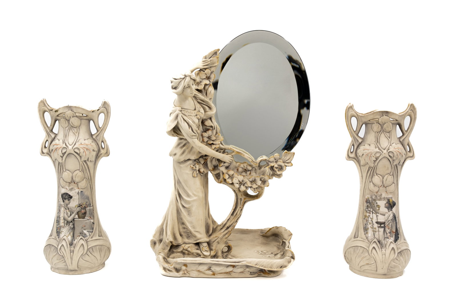 A composed lot of three Bohemian Royal Dux porcelain items: Lot 748. A composed lot of three Bohemian Royal Dux porcelain items, one mirror decorated with a lady near a tree and one pair of vases decorated with gardening scenes. Marked and 20th Century. H: 31 