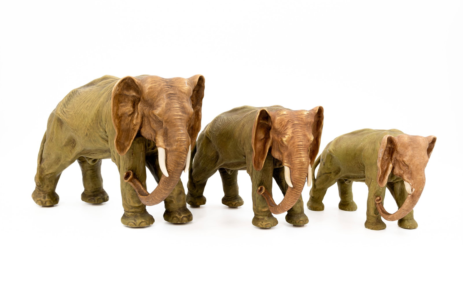 A composed lot of three Czechoslovakia porcelain figures of elephants: A composed lot of three Czechoslovakia porcelain figures of elephants. Identical model in different sizes. Marked and 20th Century. H: 17,5 - 21,5 - 26,5 cm
