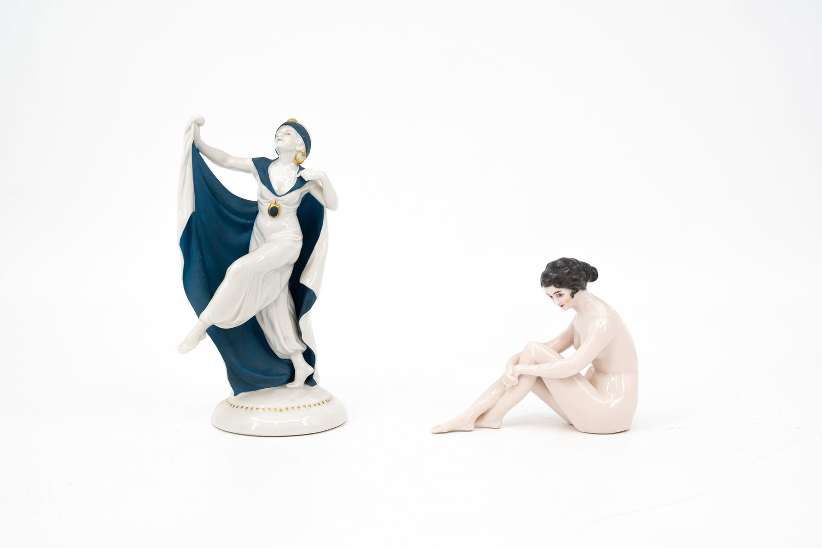 A lot of two art deco style glazed porcelain figurines: A lot of two art deco style glazed porcelain figures of a female dancer and a resting nude lady. Largest marked by Hertwig & cie - Katzhütte. First half 20th century. H: 12 - 21 cm
