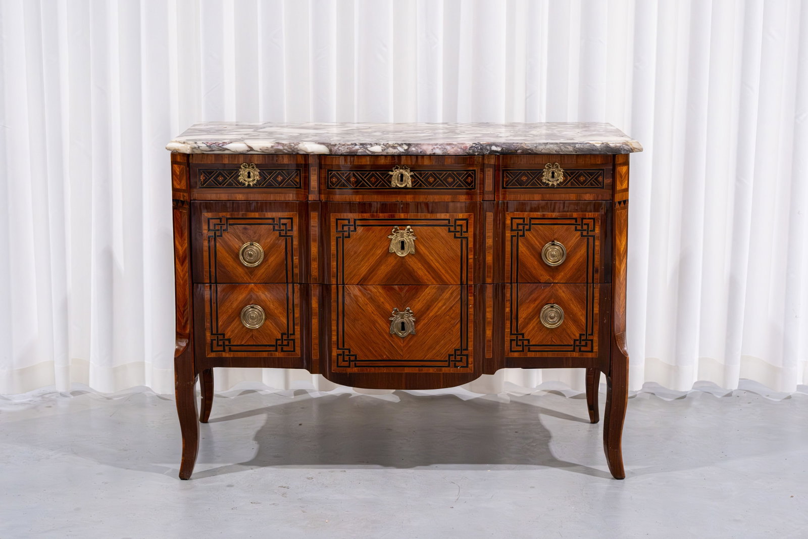 An antique Transitional-style commode with veneer, marquetry inlay and a marble top: An antique Transitional-style chest of drawers commode with veneer, marquetry inlay and a marble top. 18th century. H: 88 - W: 120 - D: 59 cm
