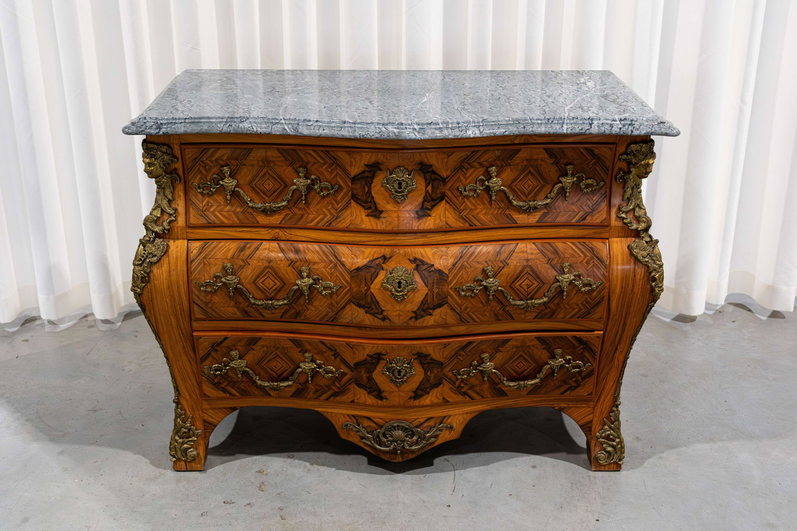 A 20th century Louis XV-style brass mounted commode with drawers and a marble top: A 20th century Louis XV Baroque-style brass mounted commode with drawers, marquetry inlay and a marble top. Circa 1970s. H: 84 - W: 110 - D: 58 cm