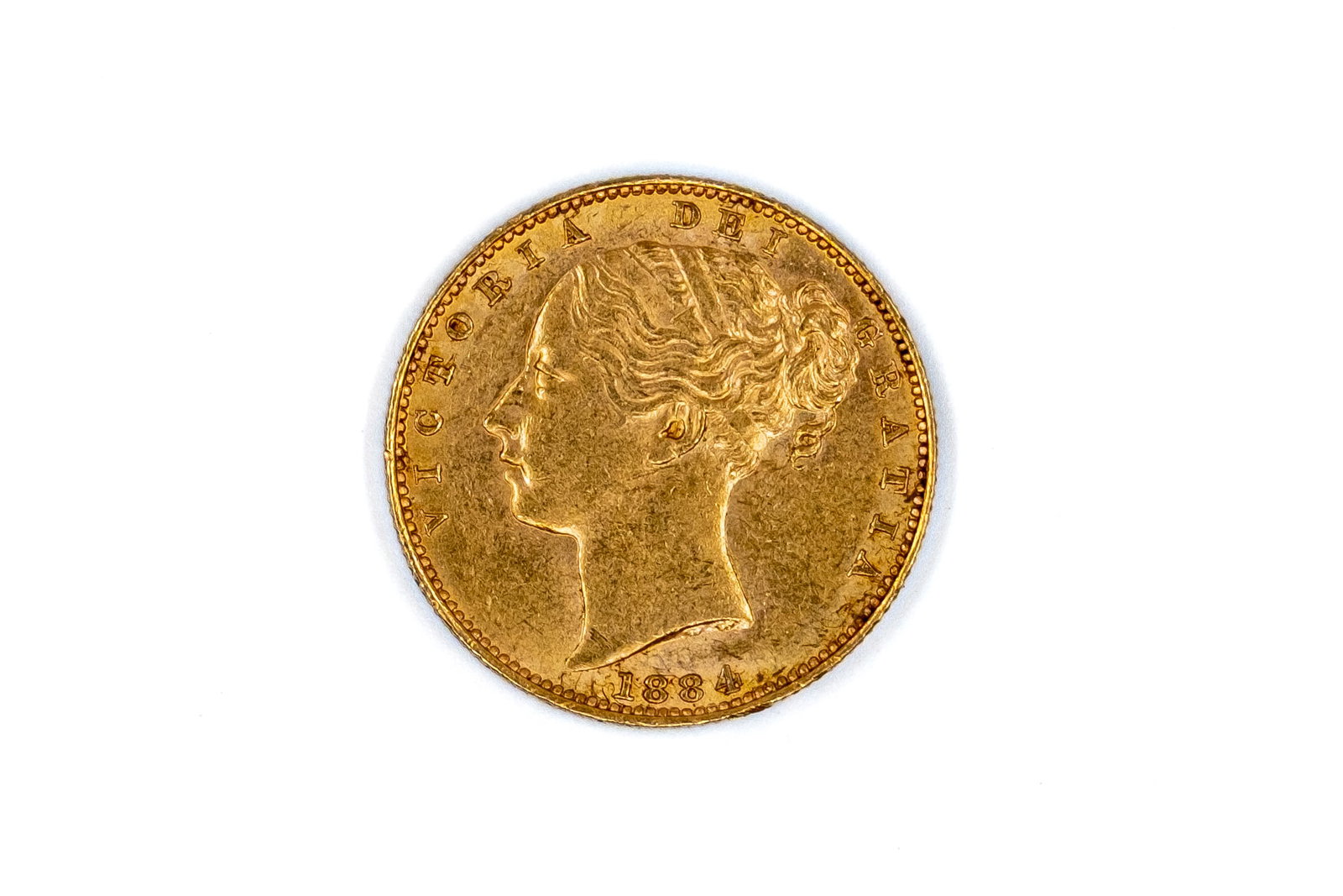 A British gold coin of Victoria, dated 1884: A British gold coin of Victoria, dated 1884. With head of Queen Victoria on the obverse, and crowned shield within wreath on the reverse. Weight: 8g