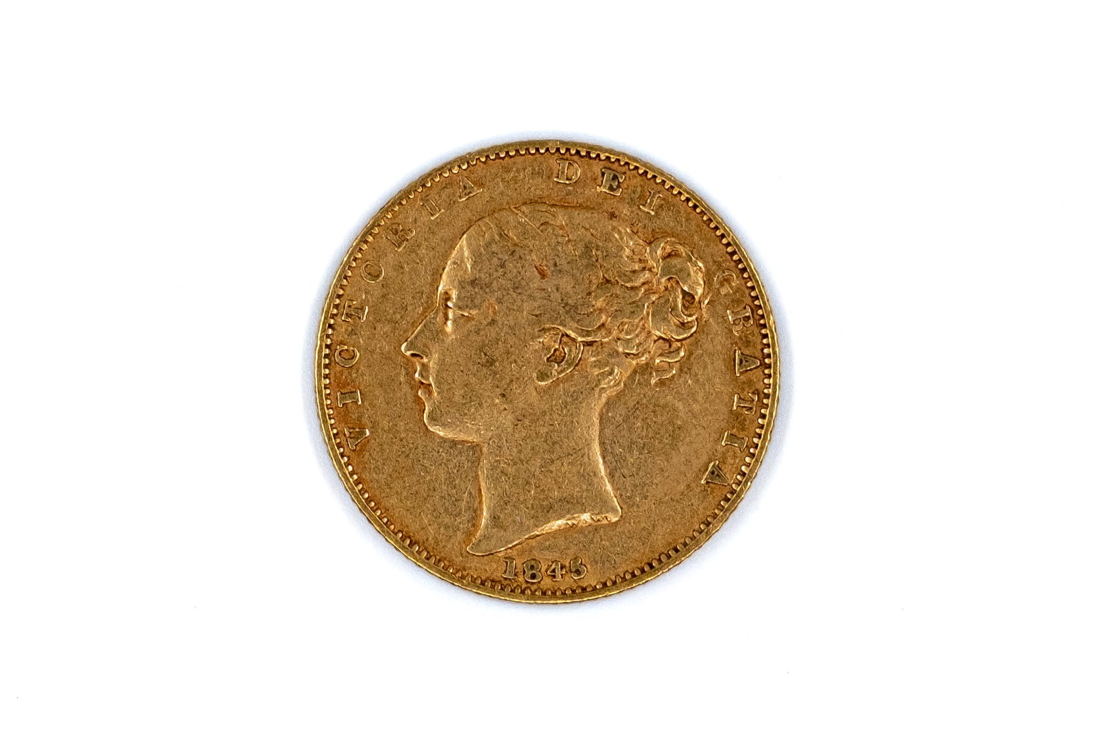 A British gold coin of Victoria, dated 1845: A British gold coin of Victoria, dated 1845. With young head of Queen Victoria on the obverse, and crowned shield within wreath on the reverse. Weight: 7,9g