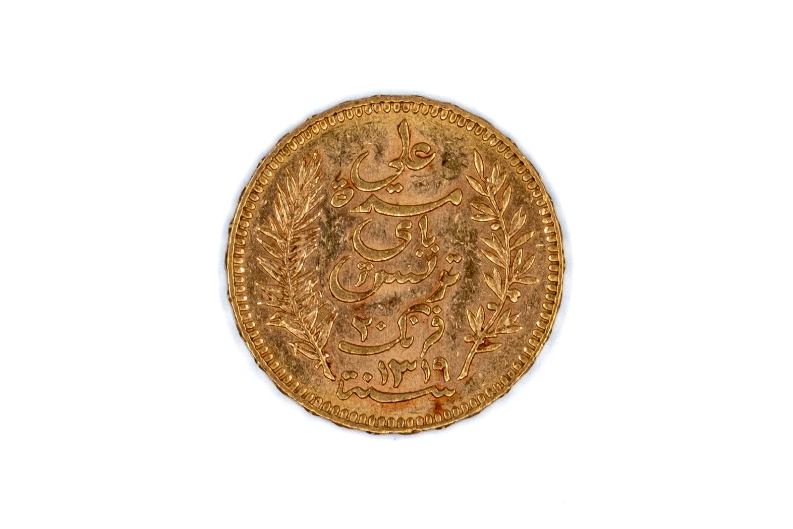 A Tunisian gold 20 Francs coin, dated 1901.: A Tunisian gold 20 Francs coin, dated 1901. With Arabic inscription within wreath on the obverse, and denomination and date within ornamental border on the reverse. Weight: 6,45g
