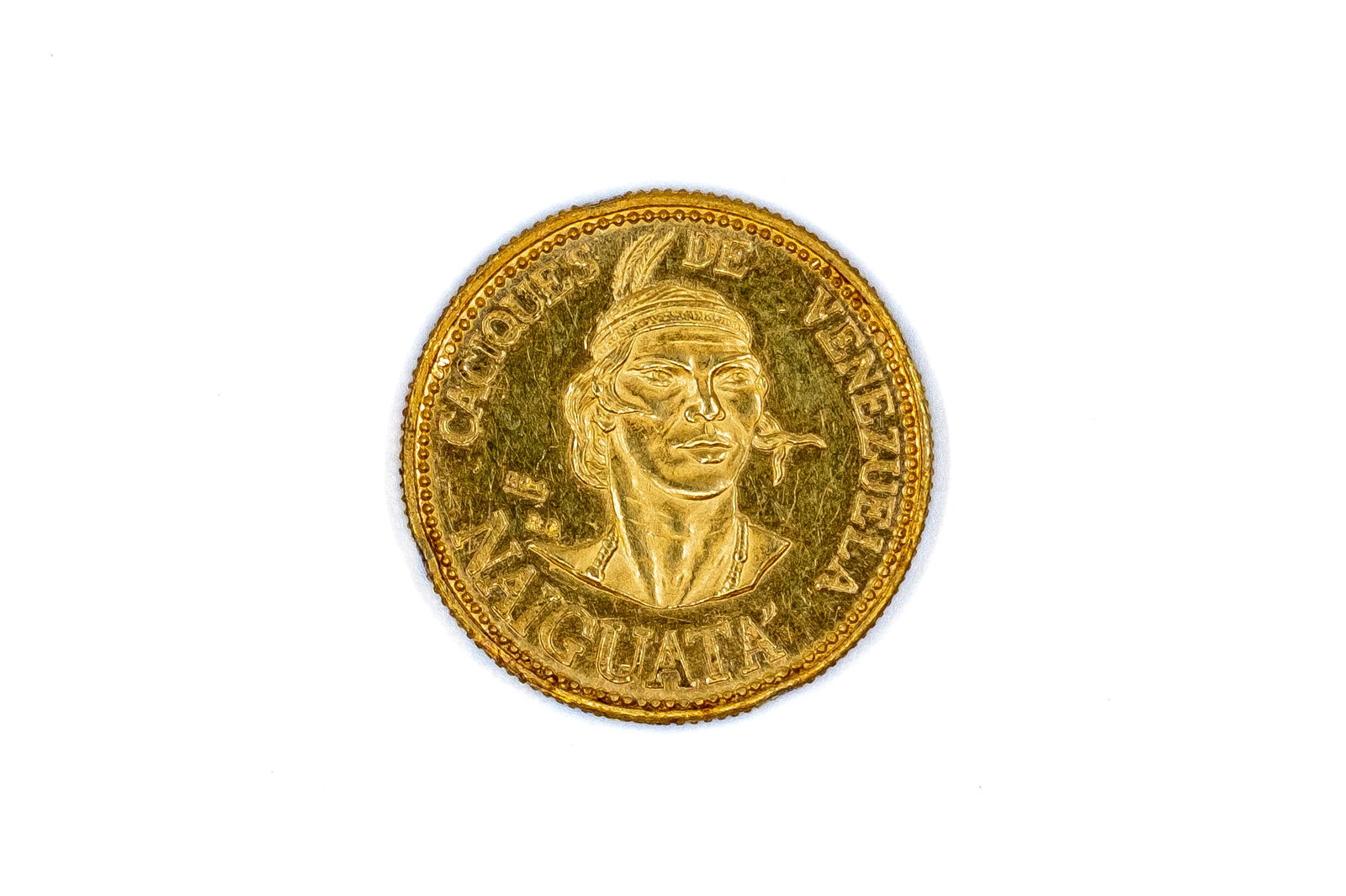 A Venezuelan gold Caciques coin: A Venezuelan gold Caciques coin. With bust of Indian chief on the obverse, and denomination and clasped hands on the reverse. Weight: 6g
