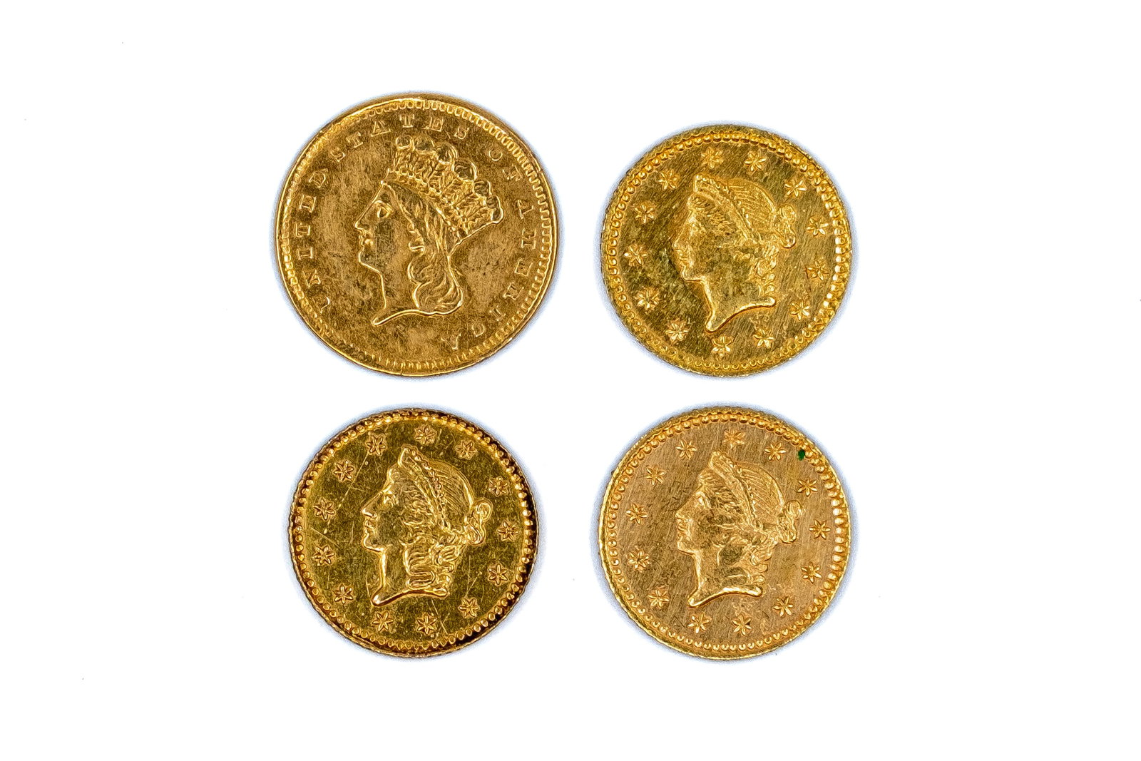 Four United States gold dollars: Four United States gold dollars, including an 1856 Indian Princess type and three Liberty Head examples dated 1853. With Indian Princess head and Liberty Head portraits on the obverses, and denominati