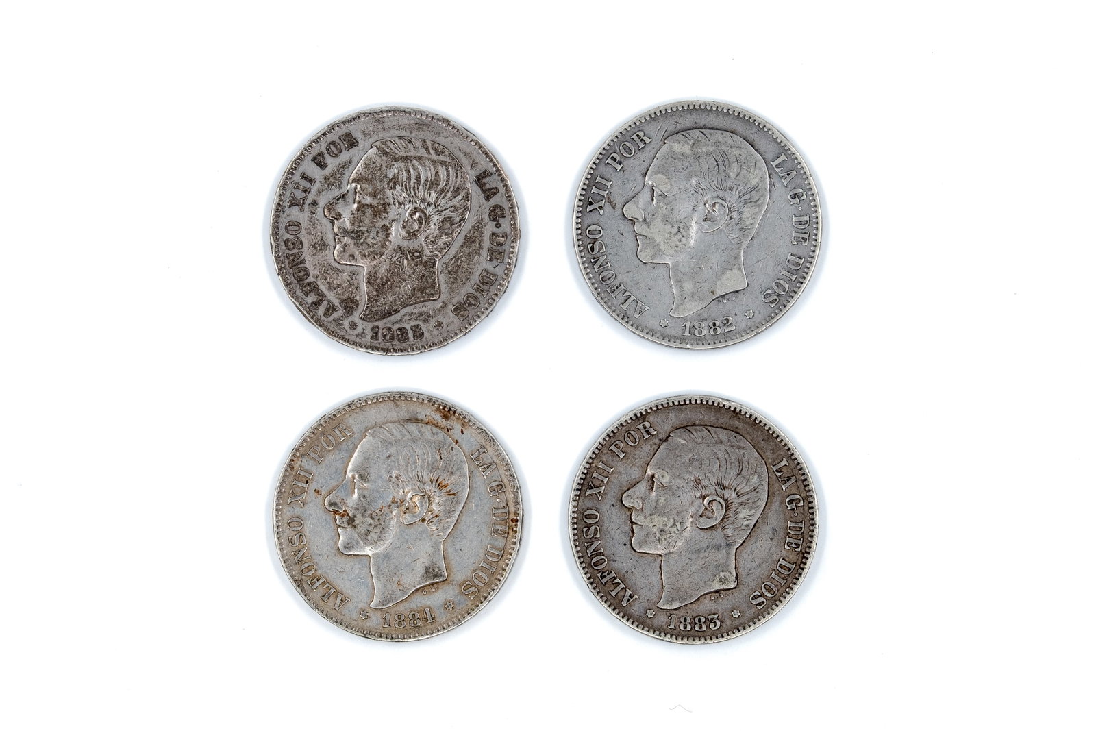 A lot of four Spanish silver 5 Pesetas coins of Alfonso XII: A lot of four Spanish silver 5 Pesetas coins of Alfonso XII, dated 1881, 1882, 1884, and 1885. With portrait of the king on the obverse and crowned arms within pillars on the reverse. Total weight: 99