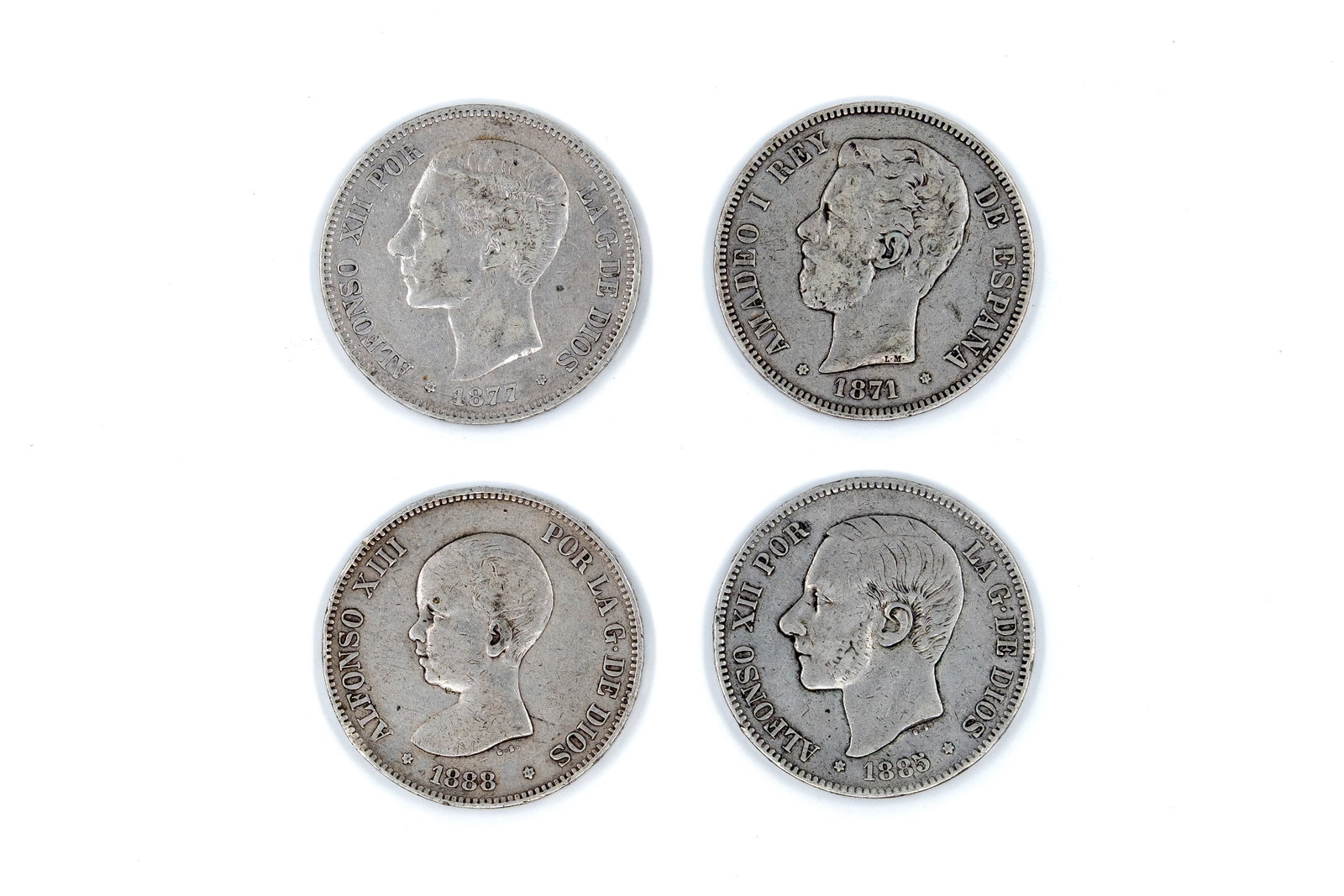 A lot of four Spanish silver 5 Pesetas coins: A lot of four Spanish silver 5 Pesetas coins, comprising issues of Amadeo I (dated 1871), Alfonso XII (dated 1877 and 1885), and Alfonso XIII (dated 1888). With portraits of the respective kings on th