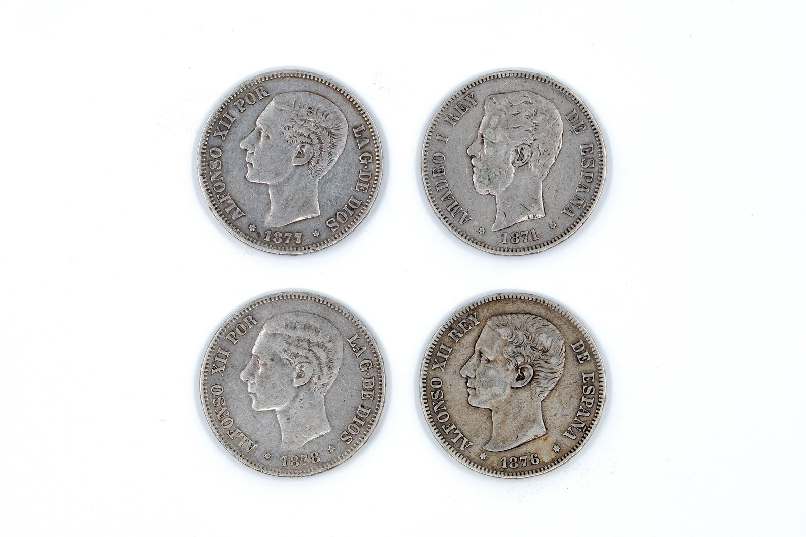 A lot of four Spanish silver 5 Pesetas coins: A lot of four Spanish silver 5 Pesetas coins, comprising one of Amadeo I (dated 1871) and three of Alfonso XII (dated 1876, 1877, and 1878). With portraits of the kings on the obverse and crowned arms