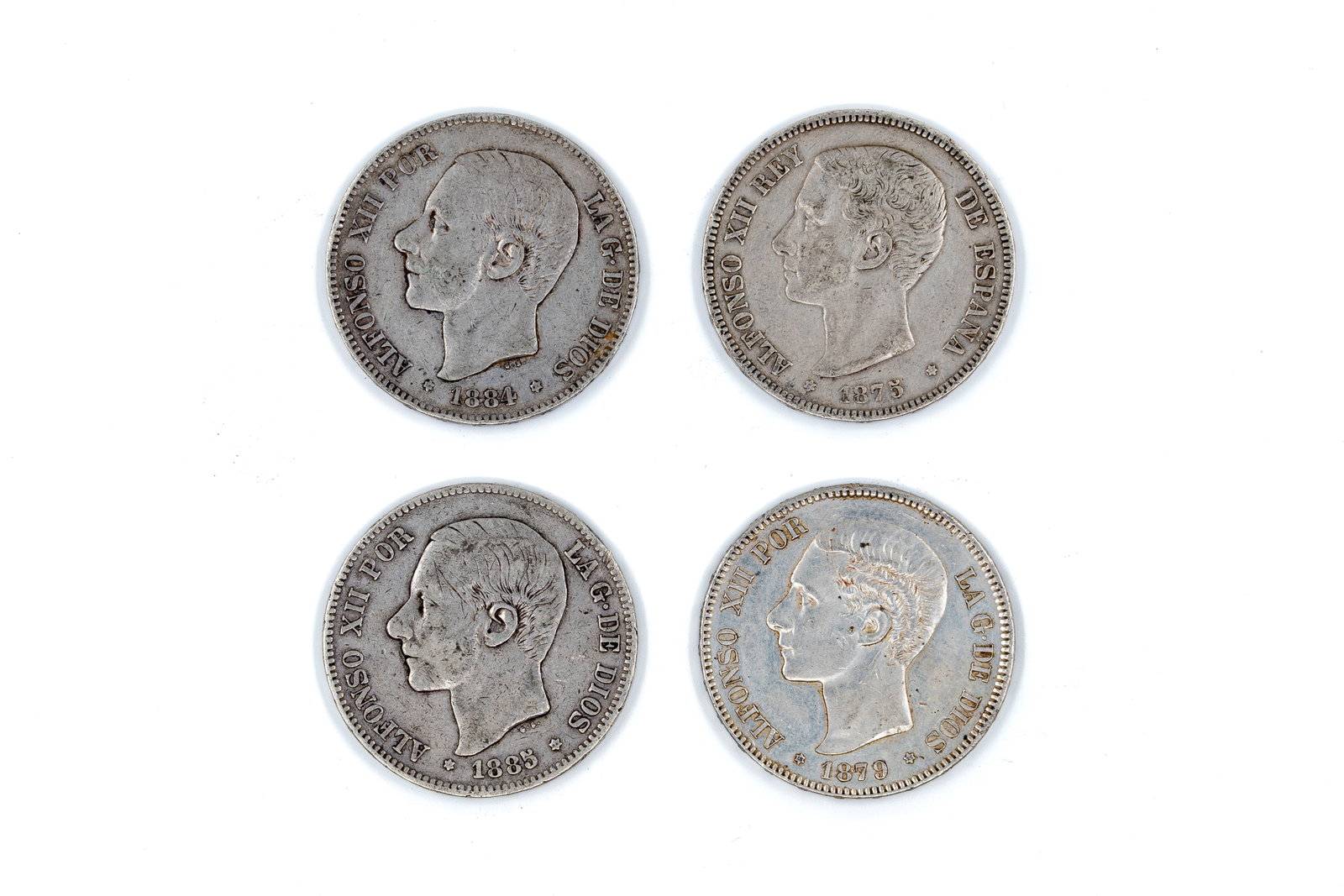 A lot of four Spanish silver 5 Pesetas coins of Alfonso XII and Alfonso XIII: A lot of four Spanish silver 5 Pesetas coins of Alfonso XII, dated 1875-1885. With portrait of the king on the obverse. Reverse with crowned Spanish coat of arms between the Pillars of Hercules and de