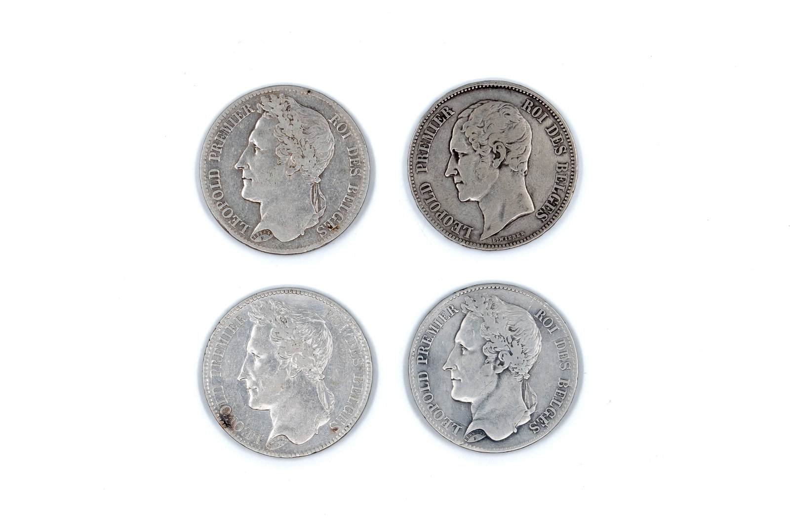A lot of four Belgian silver 5 Francs coins of Leopold I, dated 1833-1849: A lot of four Belgian silver 5 Francs coins of Leopold I, dated 1833-1849. With portrait of the king on the obverse. Reverse types including denomination within wreath and crowned Belgian coat of arms