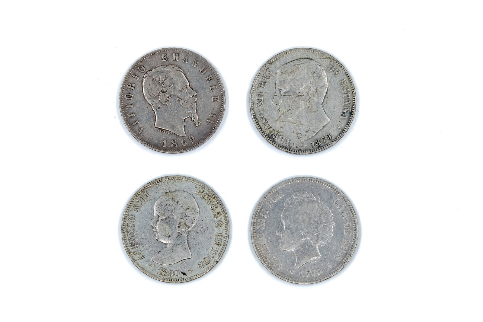 A lot of four silver coins comprising Italy and Spain, dated 1869-1893: A lot of four silver coins comprising Italy and Spain, dated 1869-1893. Including one Italian 5 Lire coin of Vittorio Emanuele II and three Spanish 5 Pesetas coins of Alfonso XII and Alfonso XIII. Obv
