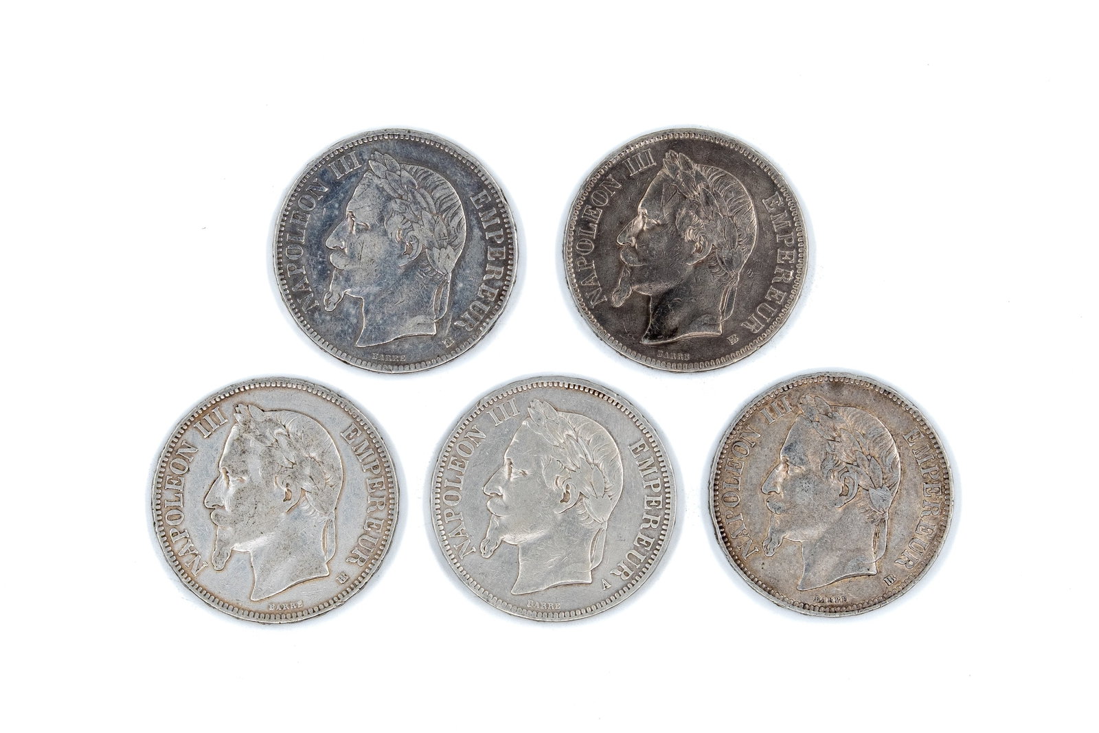 A lot of five French silver 5 Francs coins of Napoleon III, dated 1867-1869: A lot of five French silver 5 Francs coins of Napoleon III, dated 1867-1869. Comprising laureate head issues of Napoleon III facing left, with imperial titles on the obverse, and crowned arms with den