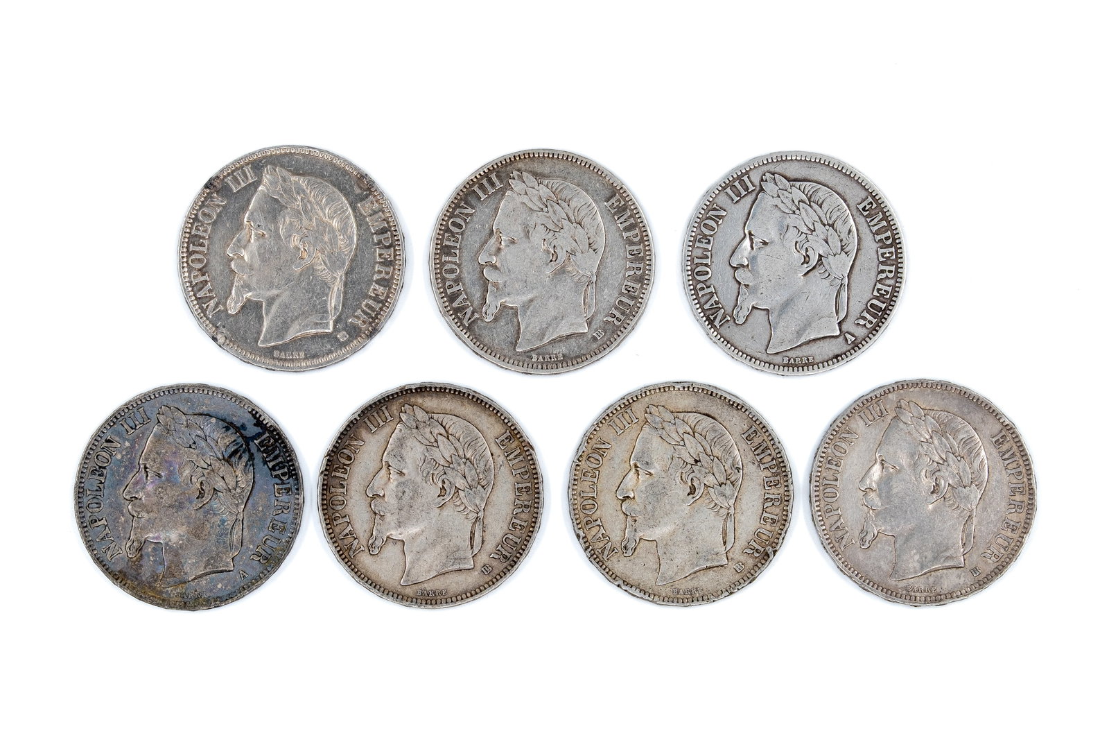 A lot of seven French silver 5 Francs coins of Napoleon III, dated 1868-1870: A lot of seven French silver 5 Francs coins of Napoleon III, dated 1868-1870. Comprising laureate head issues of Napoleon III facing left, with imperial titles on the obverse, and crowned arms with de
