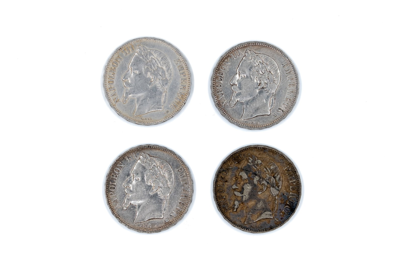 A lot of four French silver 5 Francs coins of Napoleon III, dated 1867-1869: A lot of four French silver 5 Francs coins of Napoleon III, dated 1867-1869. Comprising laureate head issues of Napoleon III facing left, with imperial titles on the obverse, and crowned arms with den