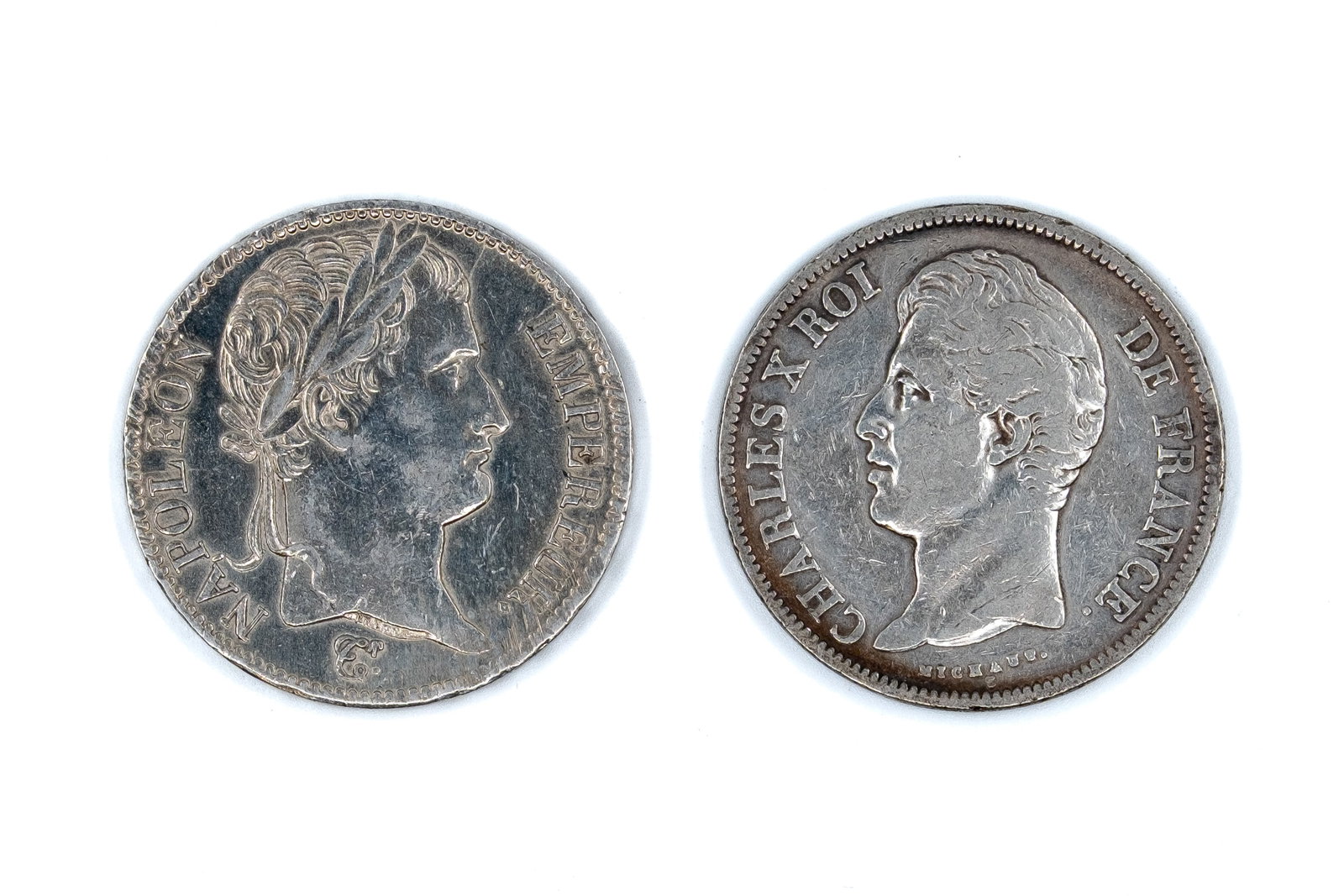 A lot of two French silver 5 Francs coins: A lot of two French silver 5 Francs coins, comprising issues of Napoleon I and Charles X, dated 1812 and 1828. Including a laureate head of Napoleon I facing right with imperial titles, and a portrait