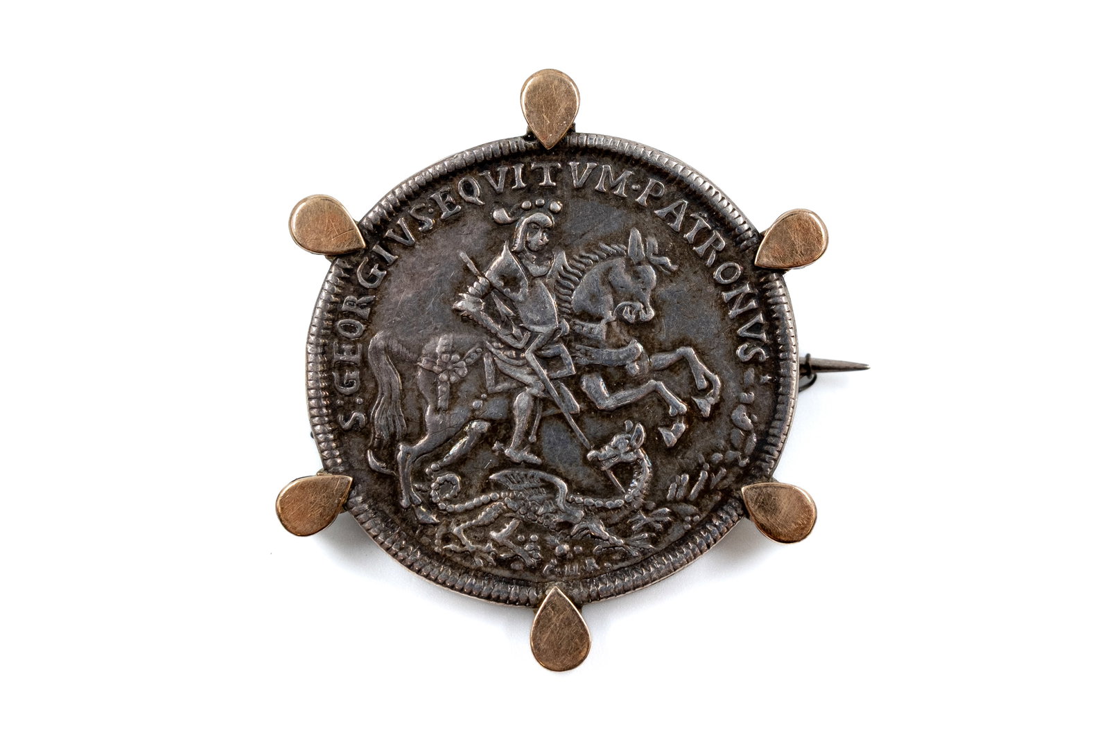One silver medal brooch, "S. Georgius Equitum Patronus": One silver medal brooch, "S. Georgius Equitum Patronus", Saint George slaying the dragon, mounted in a decorative silver-18ct gold frame with pin clasp. Weight: 29,2g