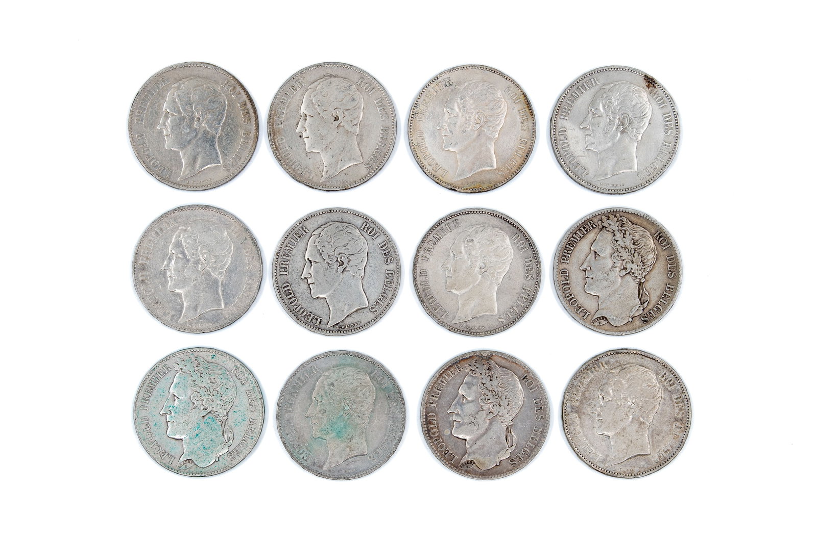 A lot of 12 Belgian silver 5 Francs coins of Leopold I, dated 1833-1865: A lot of 12 Belgian silver 5 Francs coins of Leopold I, dated 1833-1865. All coins with obverses depicting Leopold I facing right, and reverses of two types: the crowned Belgian coat of arms within a 