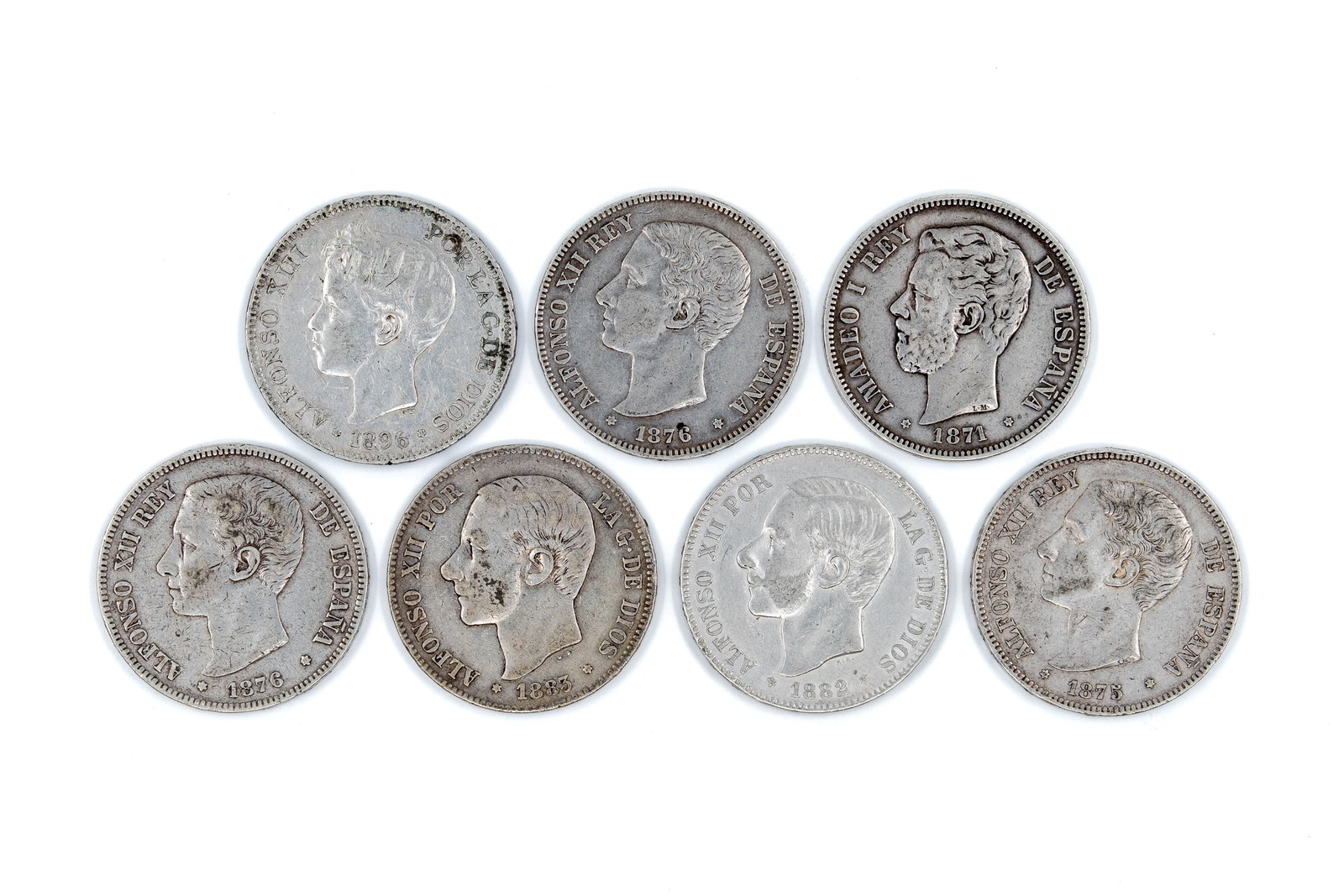 A lot of seven Spanish silver 5 Pesetas coins, dated 1871-1896: A lot of seven Spanish silver 5 Pesetas coins, dated 1871-1896. Comprising issues of Amadeo I, Alfonso XII and Alfonso XIII, with obverses depicting the respective rulers, and the reverse showing the 