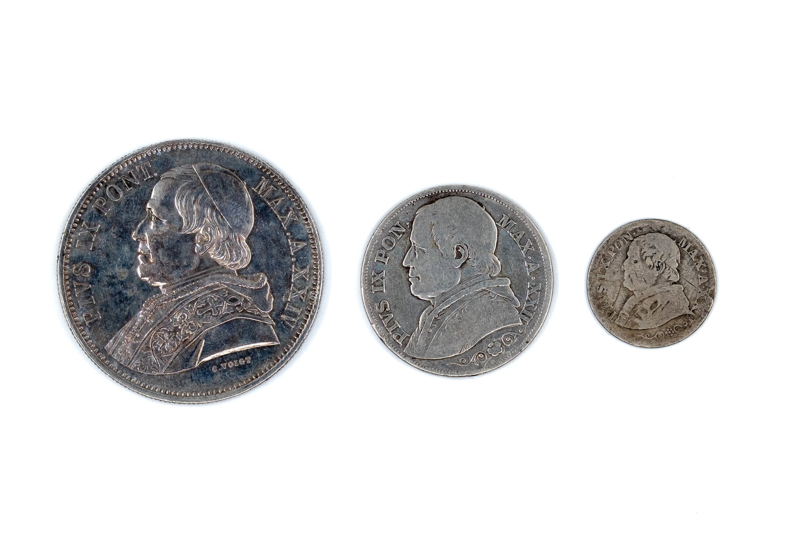 A lot of three Papal States silver coins, dated 1867-1870: A lot of three Papal States silver coins, dated 1867-1870. Comprising 5 Lire 1870, 2 Lire 1867, and 10 Soldi 1868, all depicting Pope Pius IX with denomination within wreath on reverse. Weight: 25 - 9