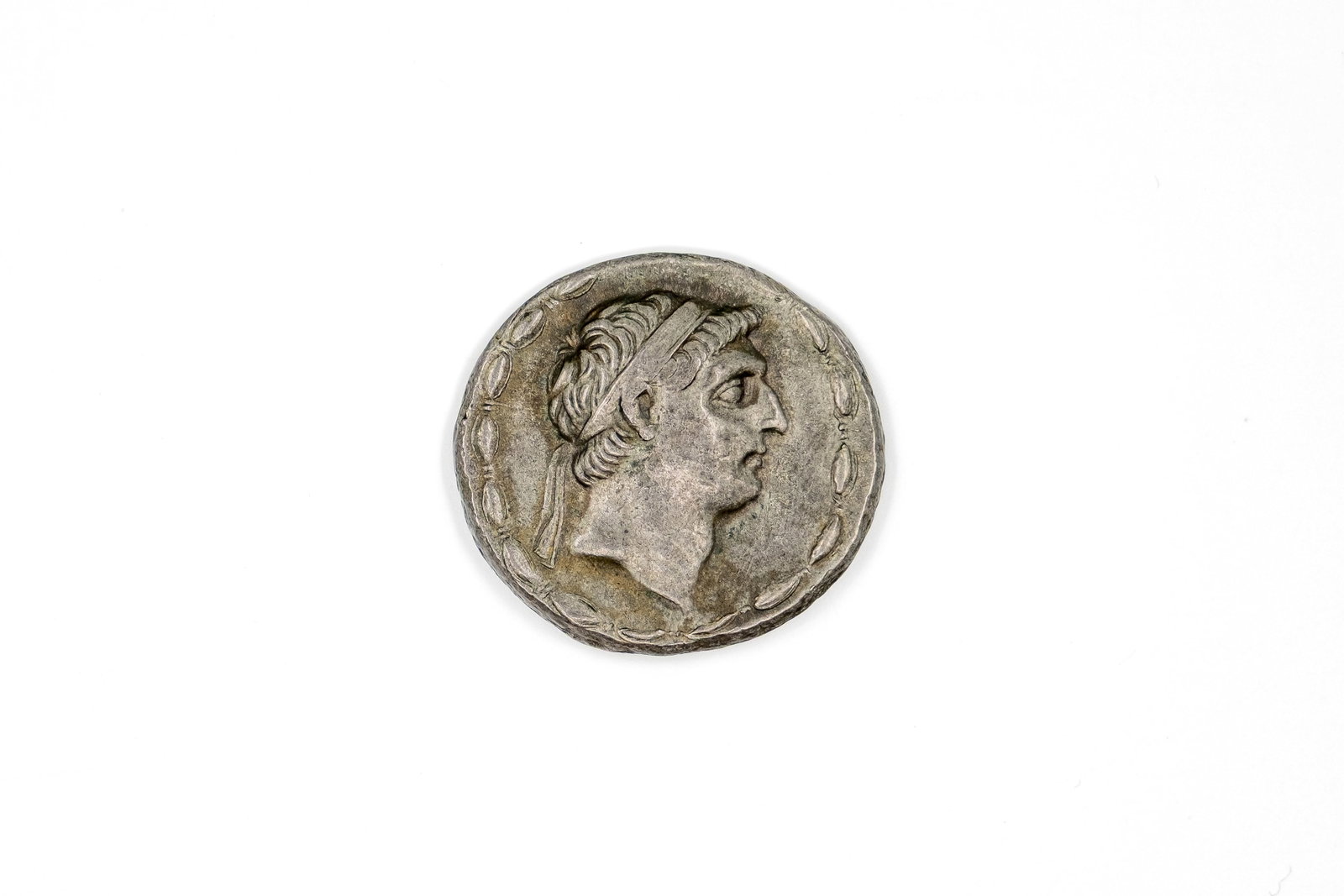 A Seleucid Kingdom silver tetradrachm coin, circa 155-150 BC: A Seleucid Kingdom silver tetradrachm coin, circa 155-150 BC. With diademed head of Demetrius obverse, the reverse with seated figure holding Nike, with Greek legend. Weight: 16,4g